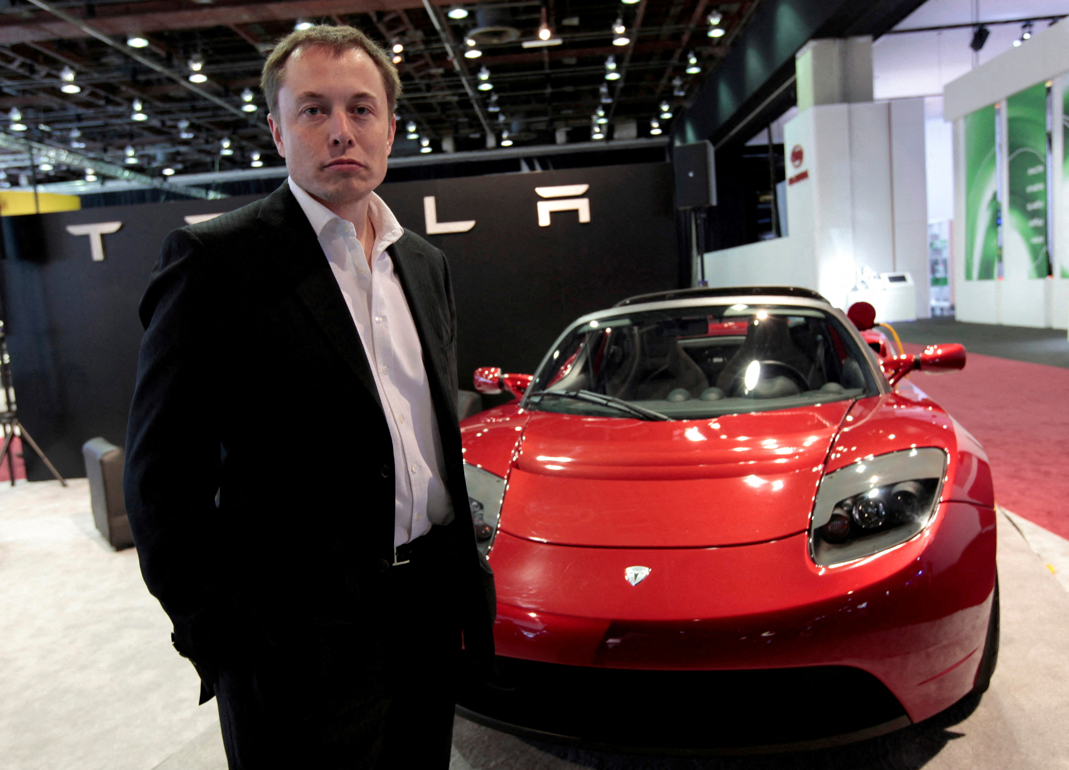 FILE PHOTO: Tesla Motors Inc. CEO and Chairman Elon Musk stands in front of the Tesla Roadster electric vehicle as he addresses the media during press days of the North American International Auto Show in Detroit