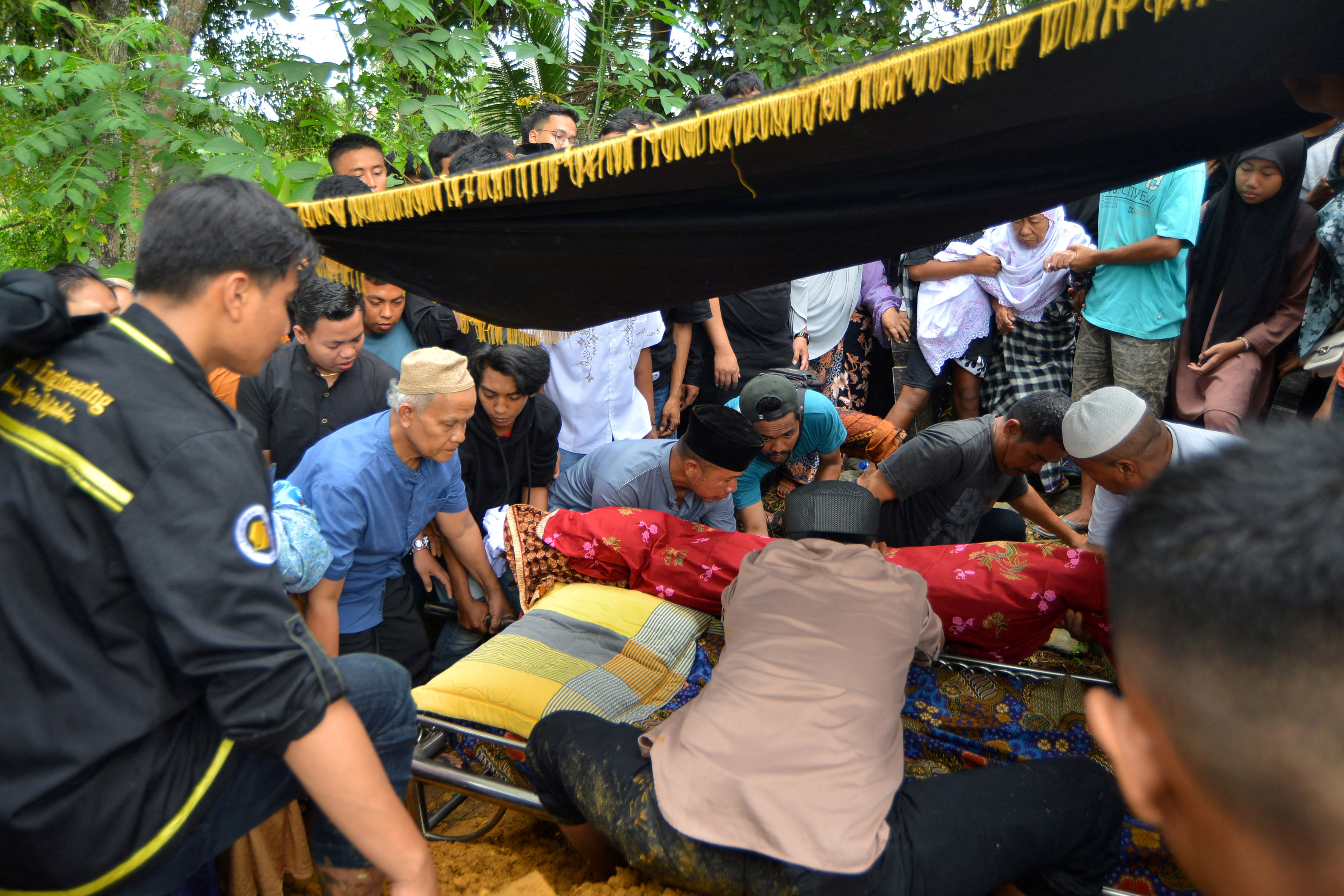 Family members bury the body of Mount Marapi eruption victim in Bandar Buat