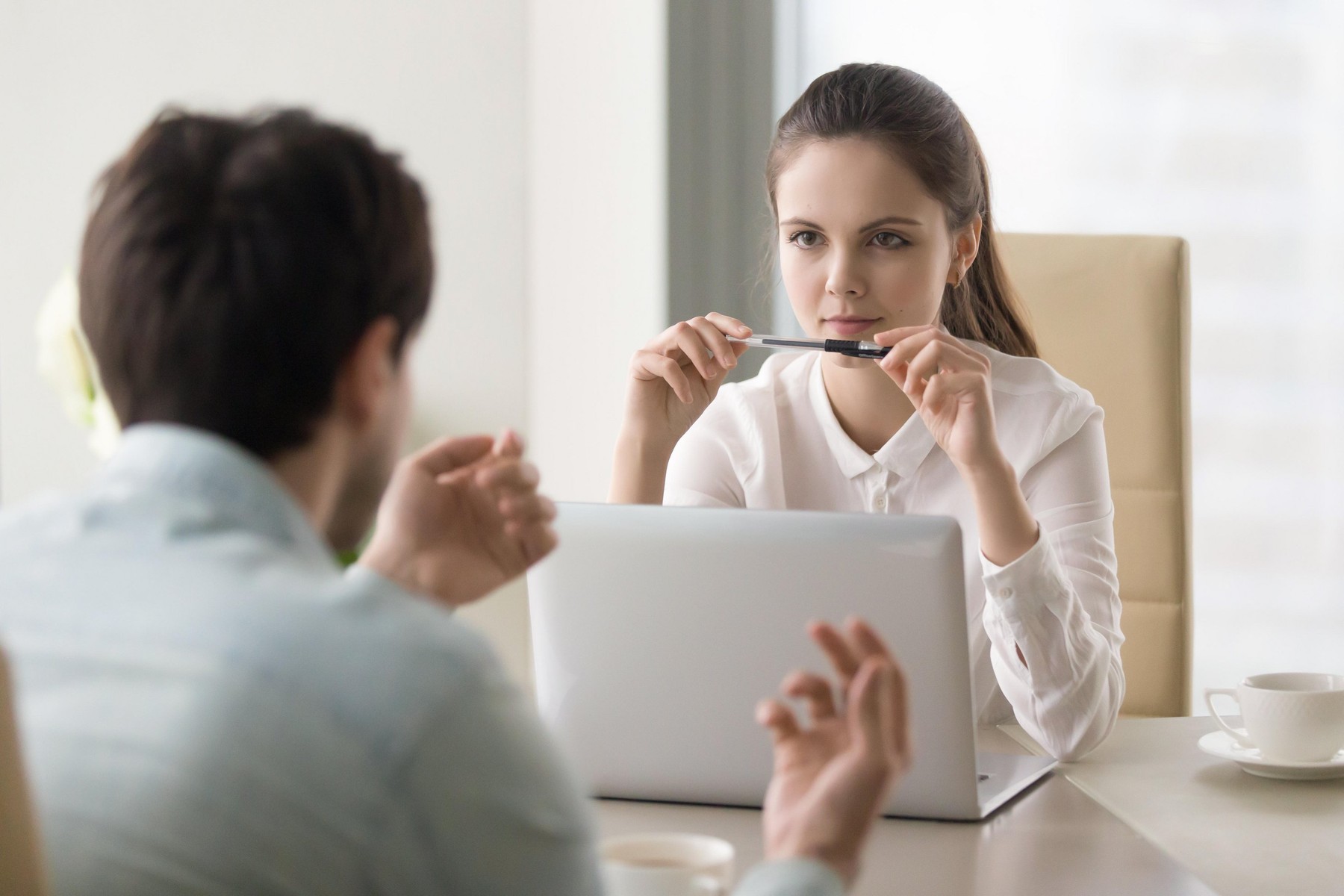 Businesswoman listening to male job applicant or considering bus