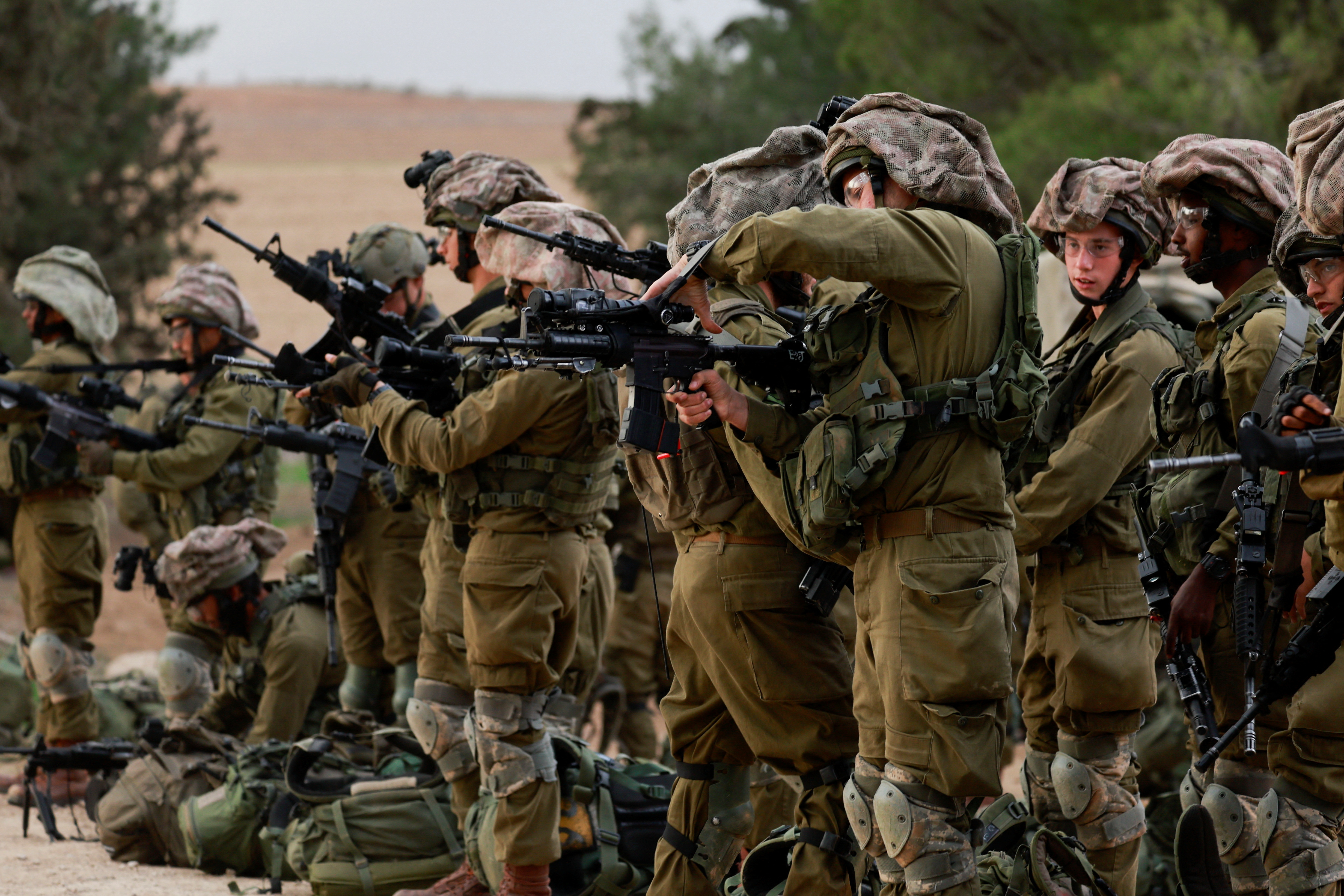 Israeli soldiers gather on the Israeli side of the Israel-Gaza border, amid the ongoing conflict between Israel and the Palestinian Islamist group Hamas, as seen from southern Israel