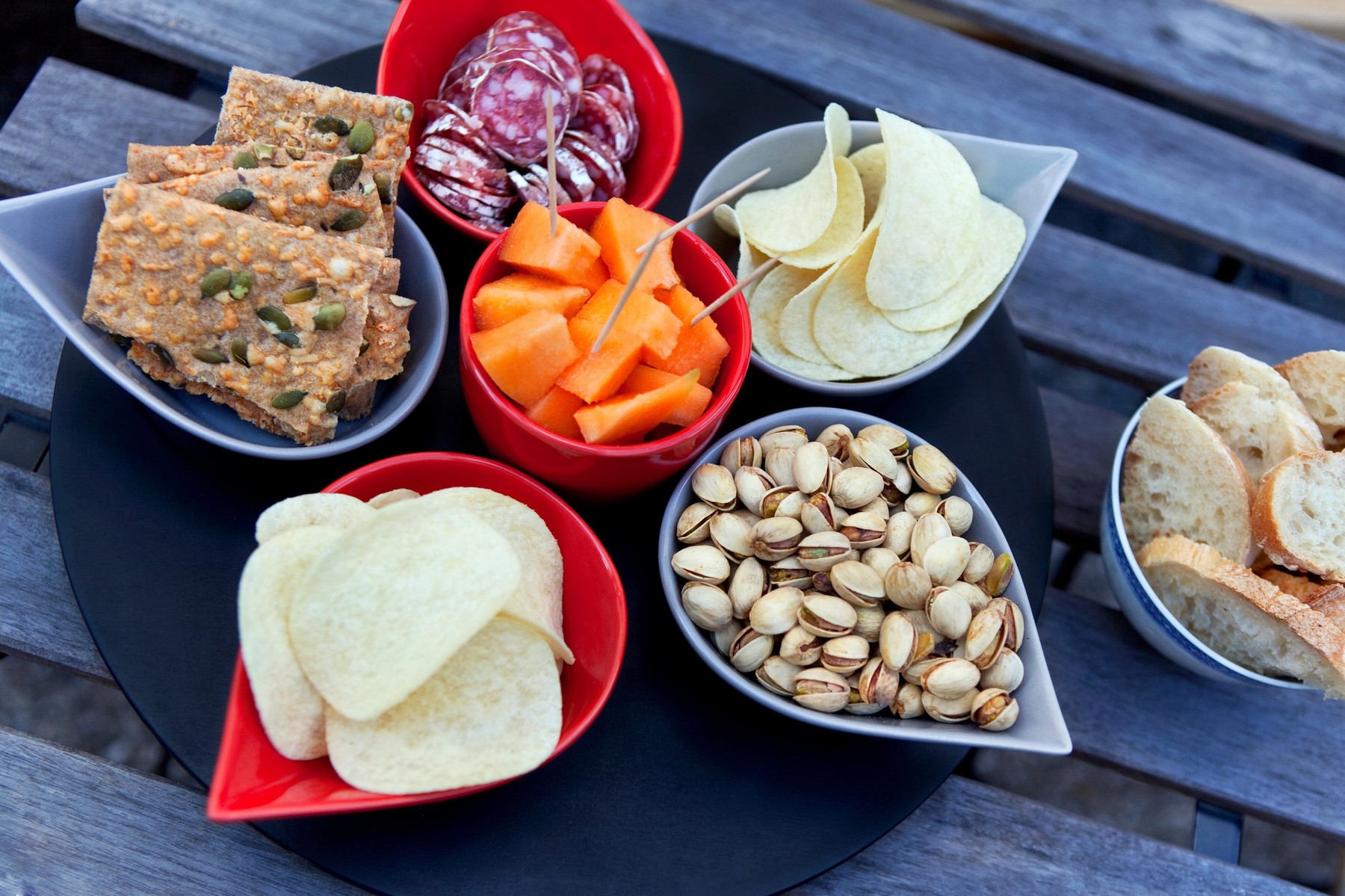 Crackers, chips, melon and sausage on a table
