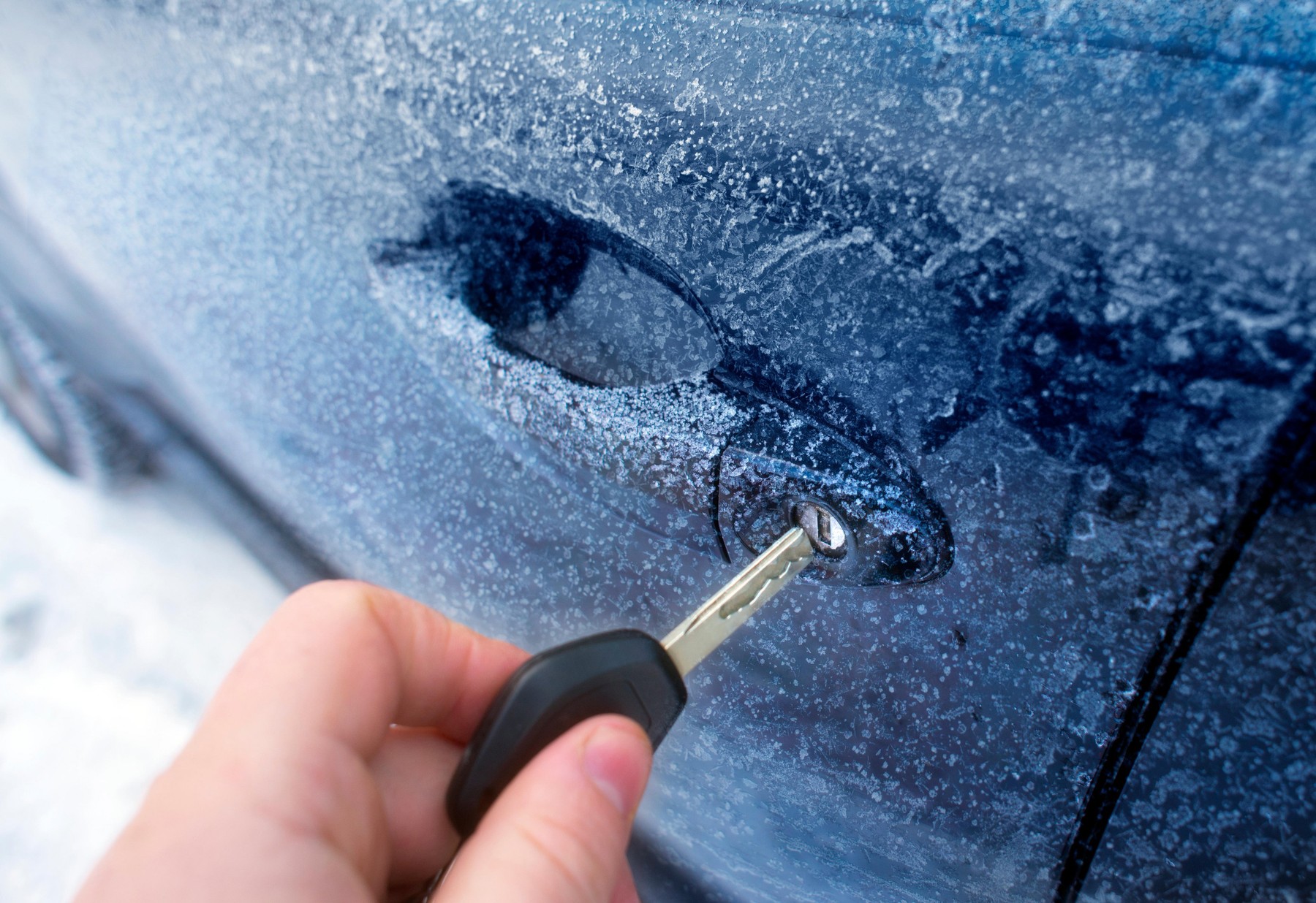Unlocking a car door on a cold frozen winter morning