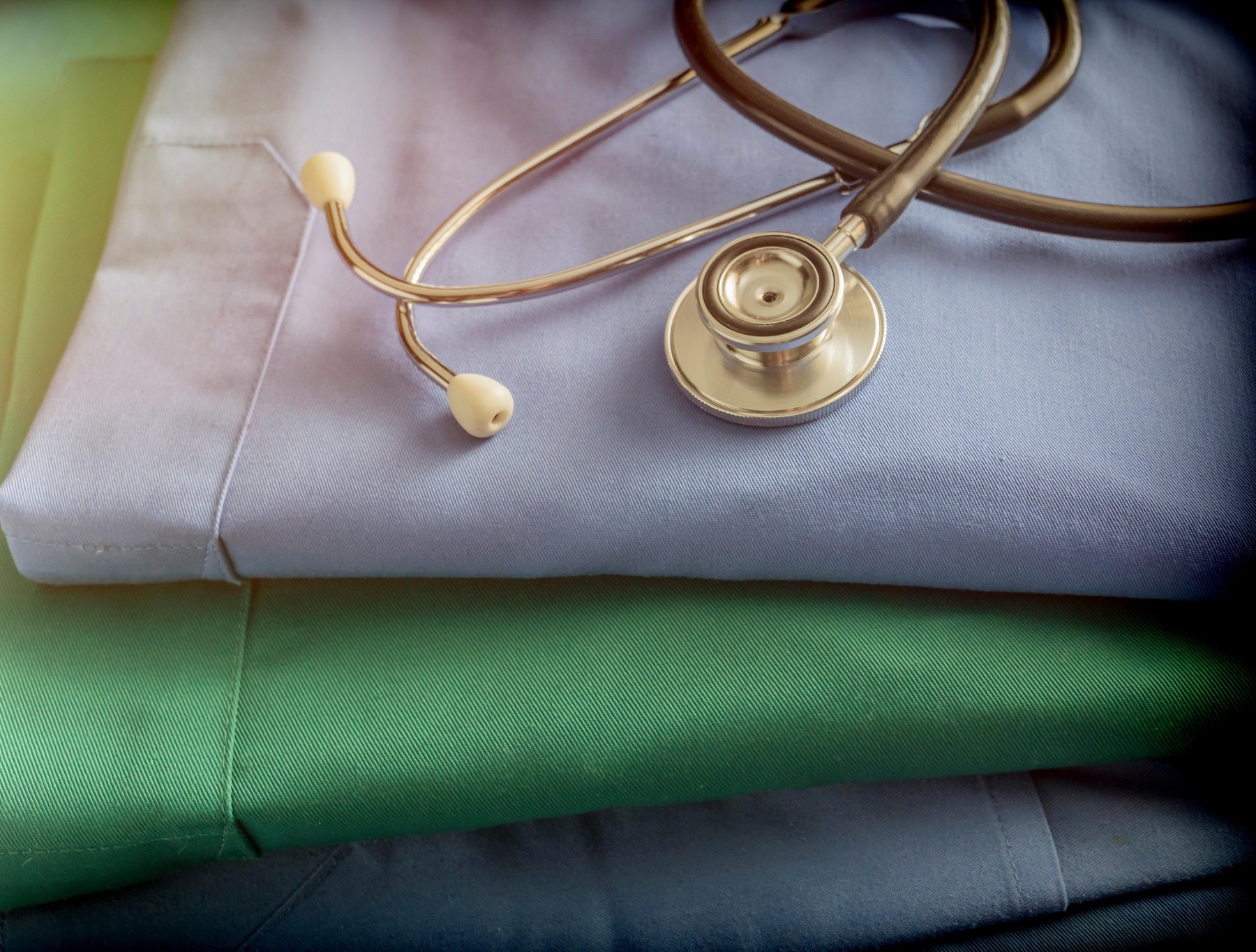 Stethoscope about blue and green nurse uniform in a hospital, conceptual image