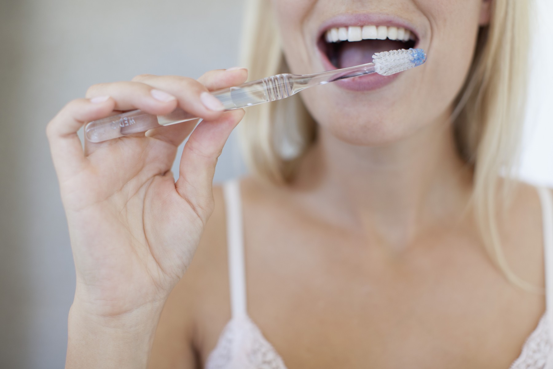 Woman brushing her teeth, cropped