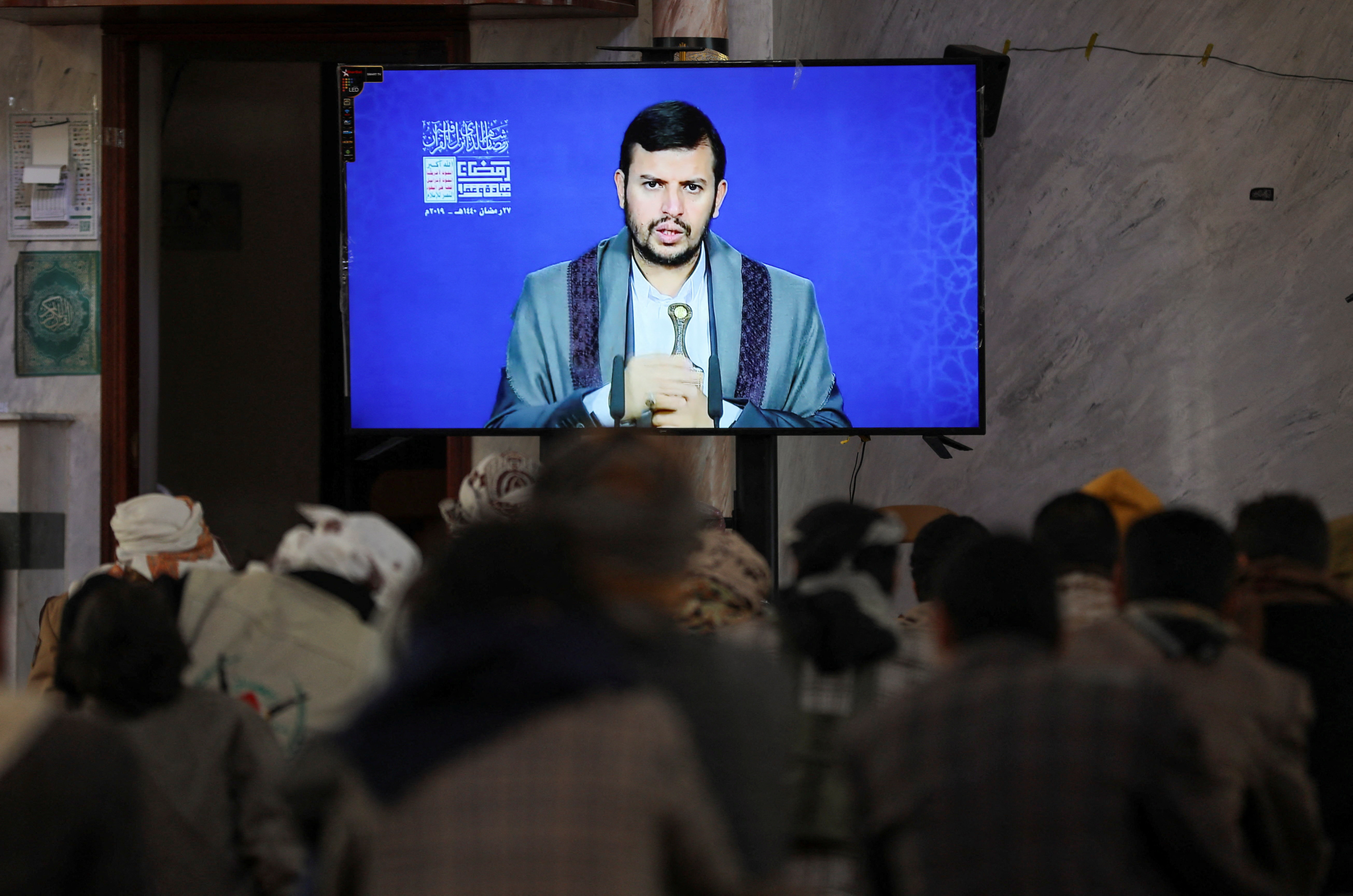 Newly recruited Houthi fighters watch a recorded lecture on Israel and the Jews by the Houthi movement's top leader, Abdul-Malik al-Houthi, during a ceremony at the end of their training in Sanaa
