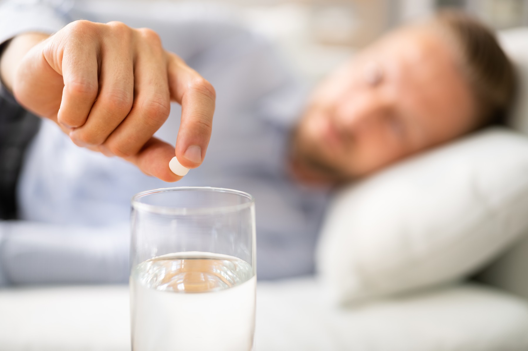 Man With Hangover Taking Medicine Pill