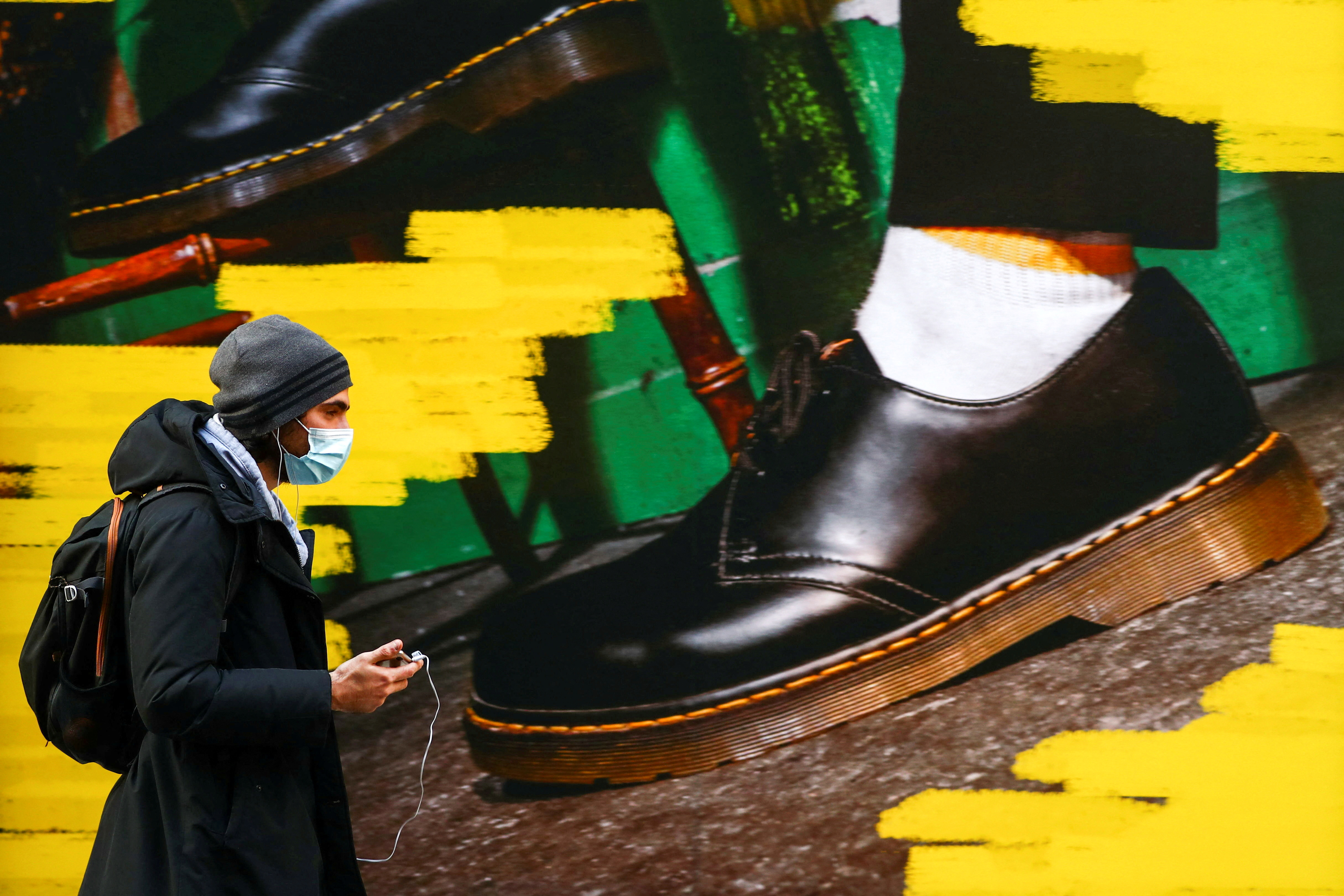 FILE PHOTO: A person walks past the window of a "Dr Martens" shoe shop amid the coronavirus disease (COVID-19) outbreak in central Madrid