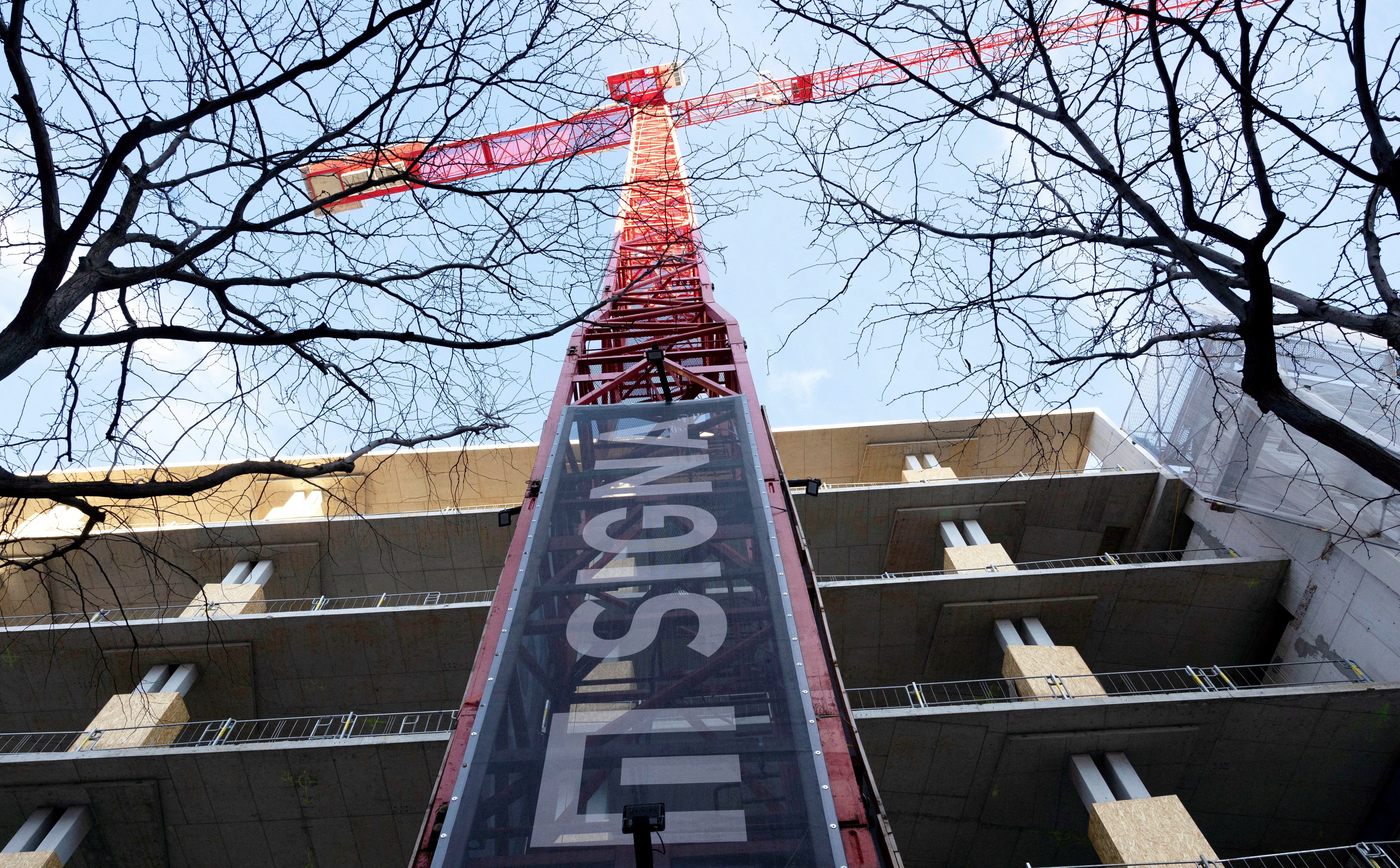 FILE PHOTO: The sign of Signa Holding is placed on a crane next to a construction site in Vienna