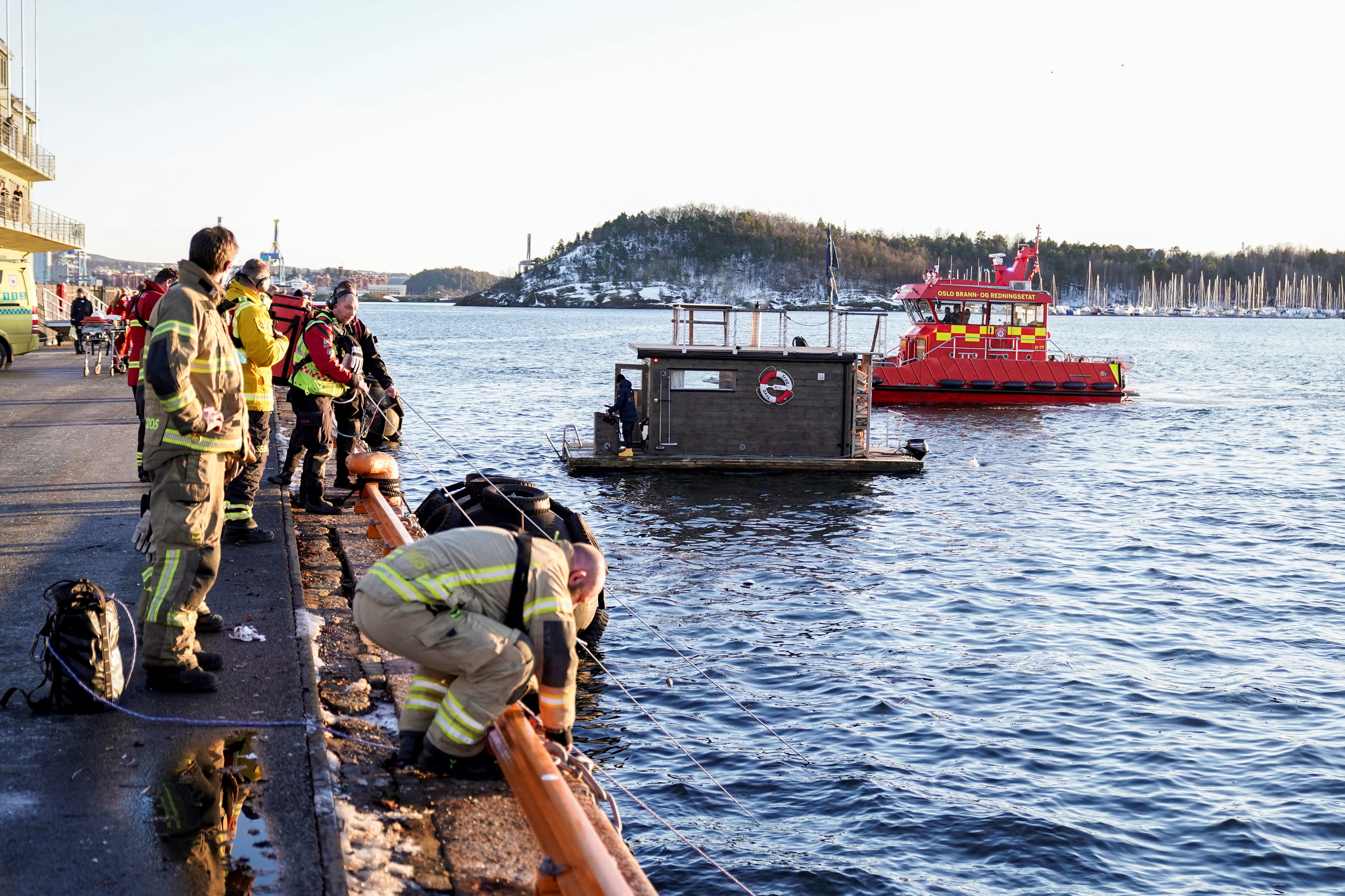 Rescuers work to retrieve a car from the Oslofjord, in Oslo
