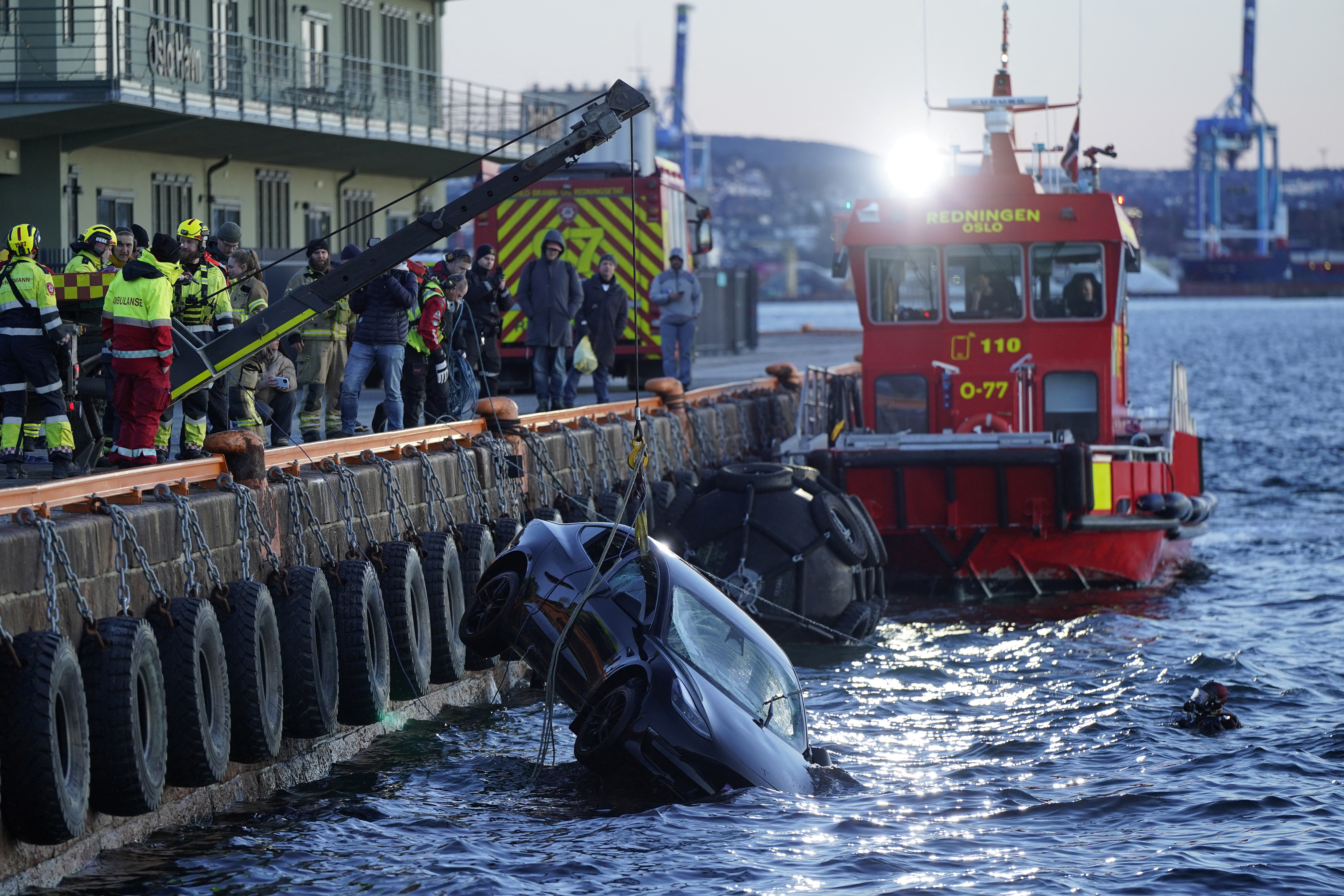 Rescuers work to retrieve a car from the Oslofjord, in Oslo