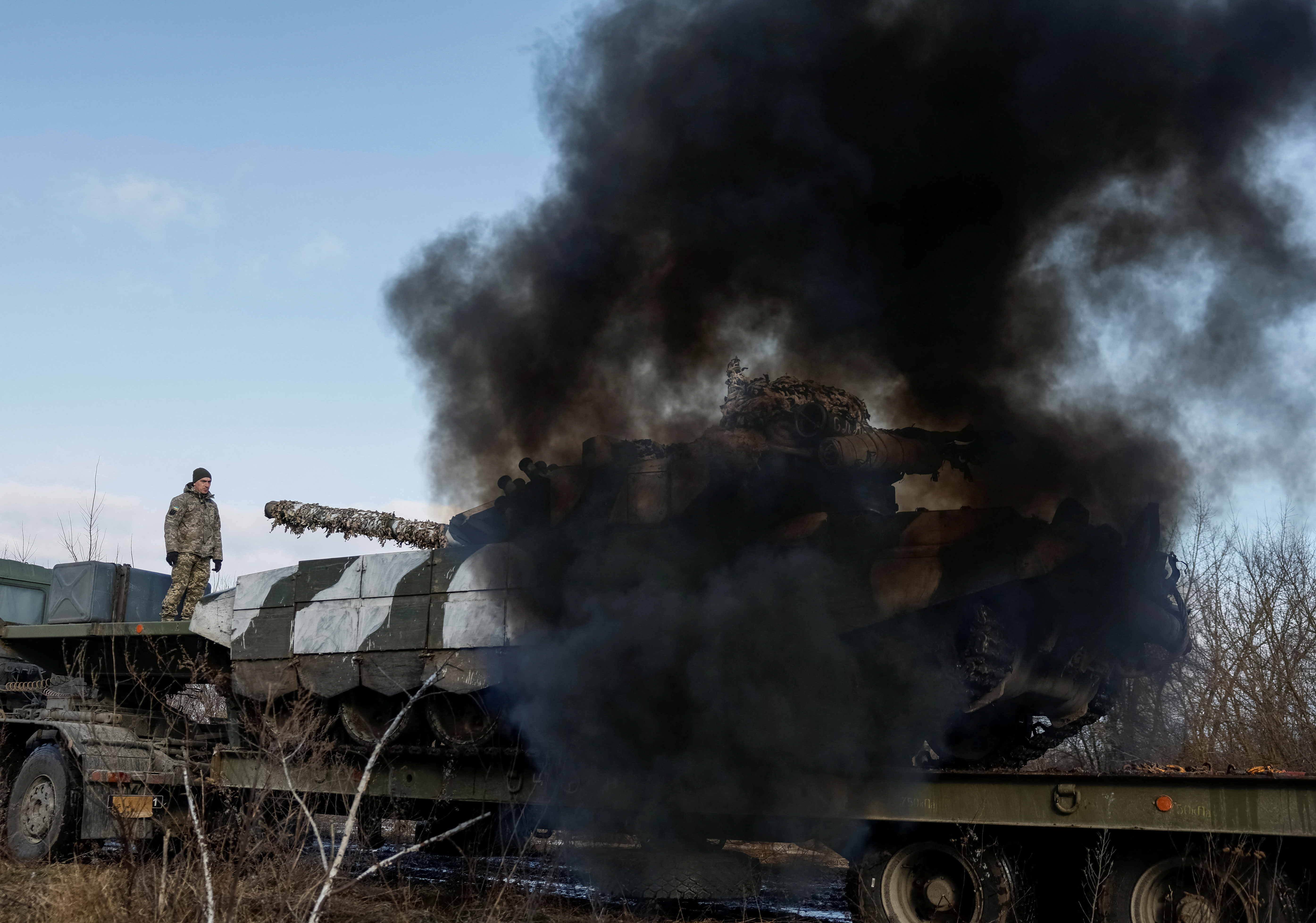 A Ukrainian tank starts engine while being unloaded for repairs in northern Ukraine