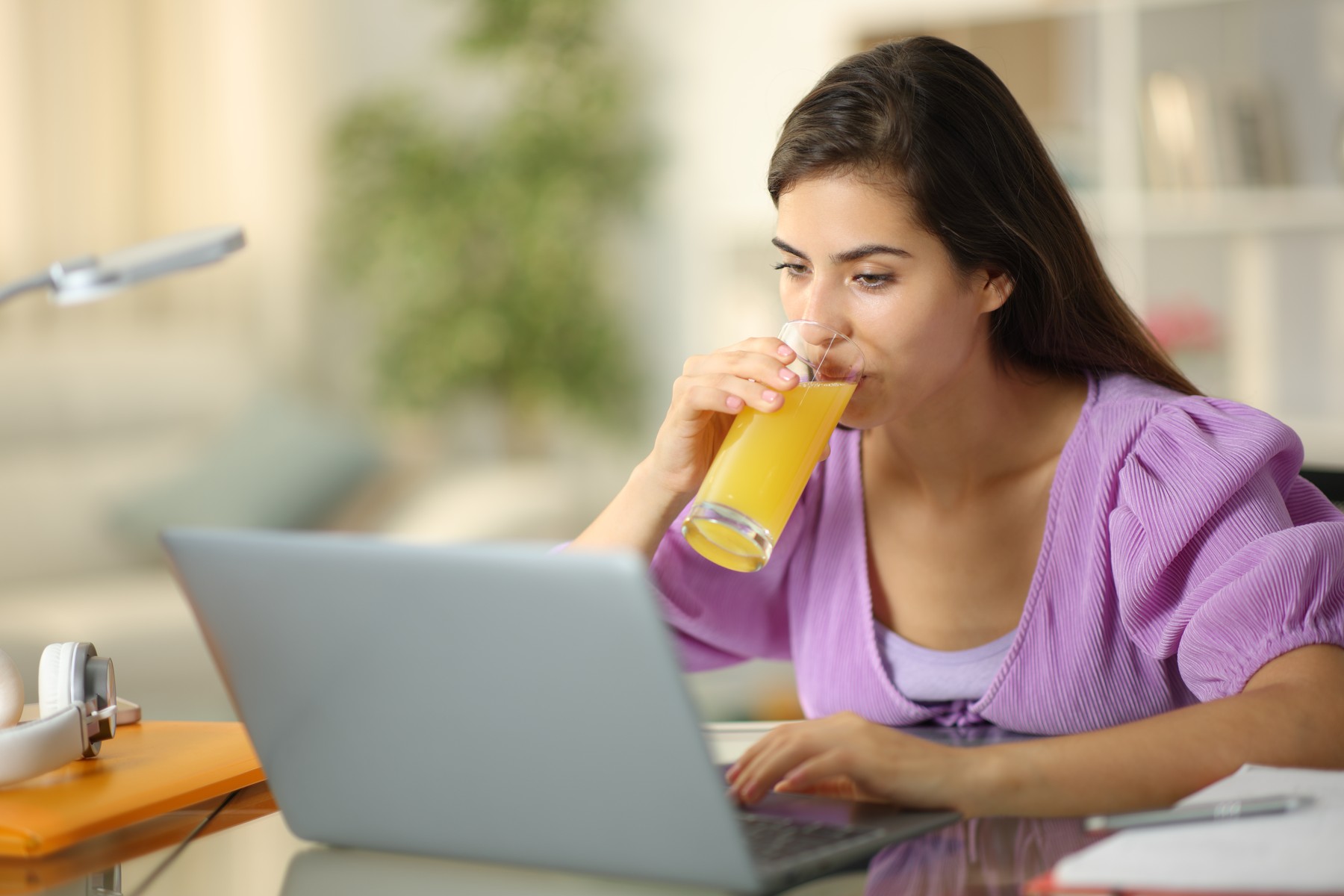 Student e-learning drinking orange juice