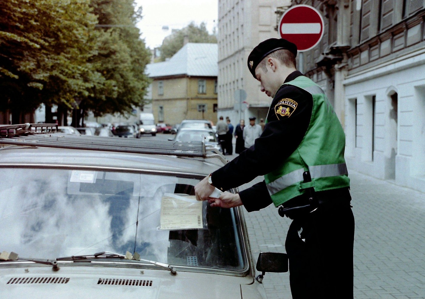 A Riga municipal police officer places a ticket for illegal parking on the windshield of a car (photo 09.2001).