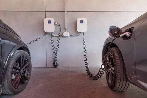 electric cars are charged at a wallbox in the garage