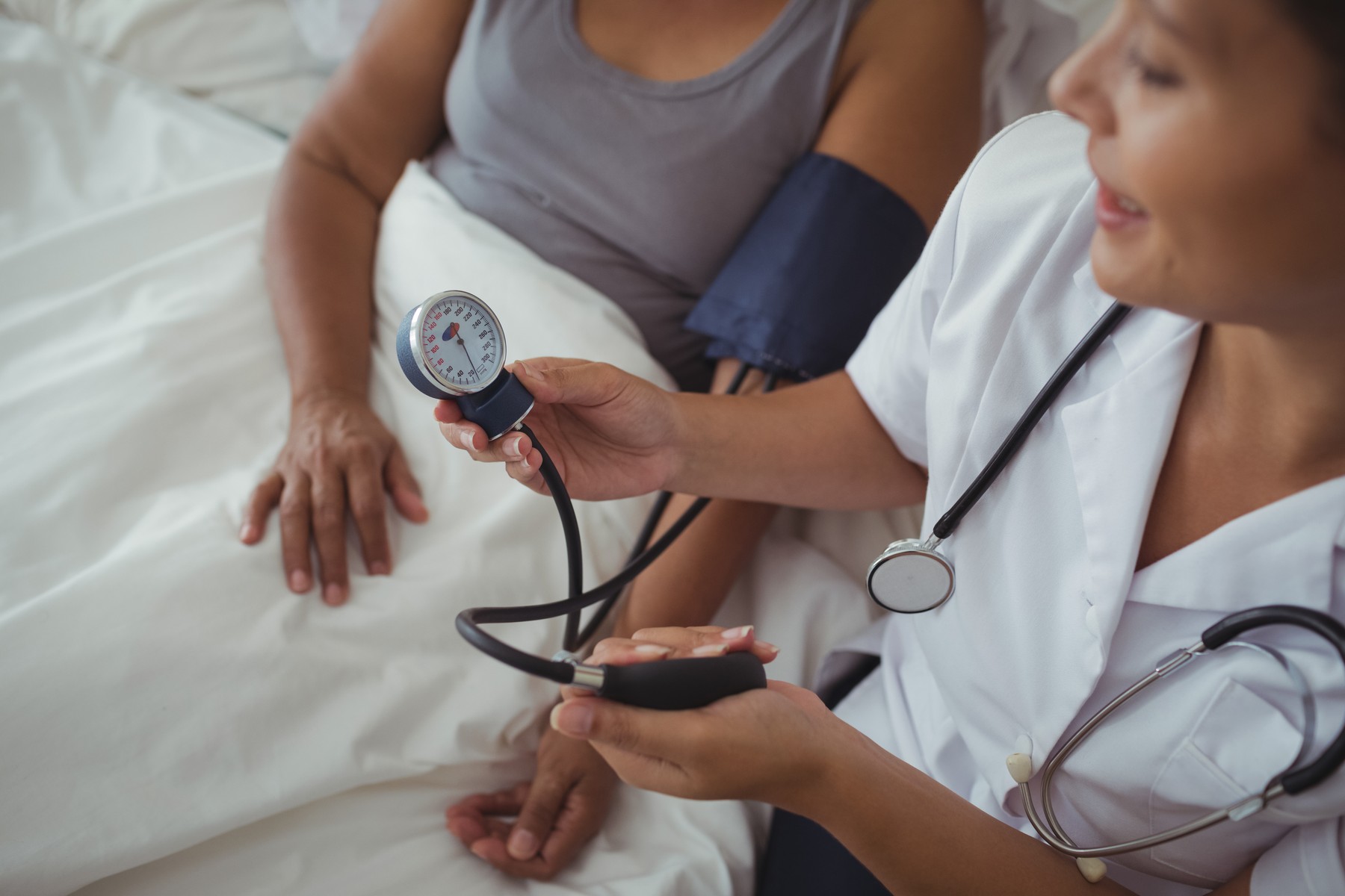 Female doctor measuring blood pressure of a senior woman