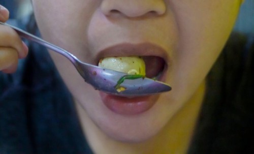 Woman eating pork meatballs, It is a popular street food that is delicious and commonly found in Asian countries such as Thailand, China, Laos, Vietna