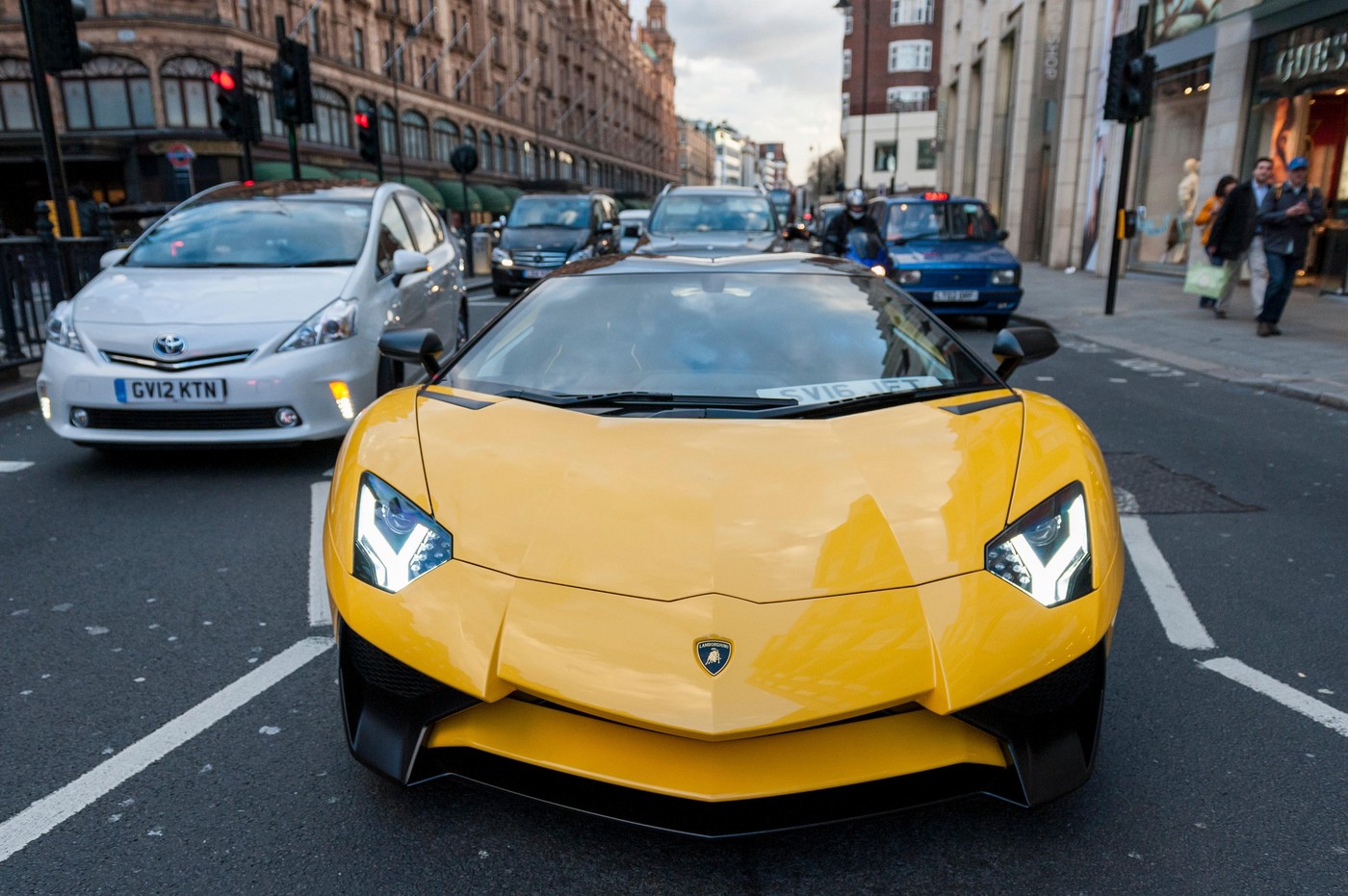 London, UK.  5 April 2016.  A bright yellow Lamborghini Aventador SV drives down the Brompton Road.  Supercars can be seen in Knightsbridge as the 'season' for Middle Eastern owned supercars is about to commence. © Stephen Chung / Alamy Live News