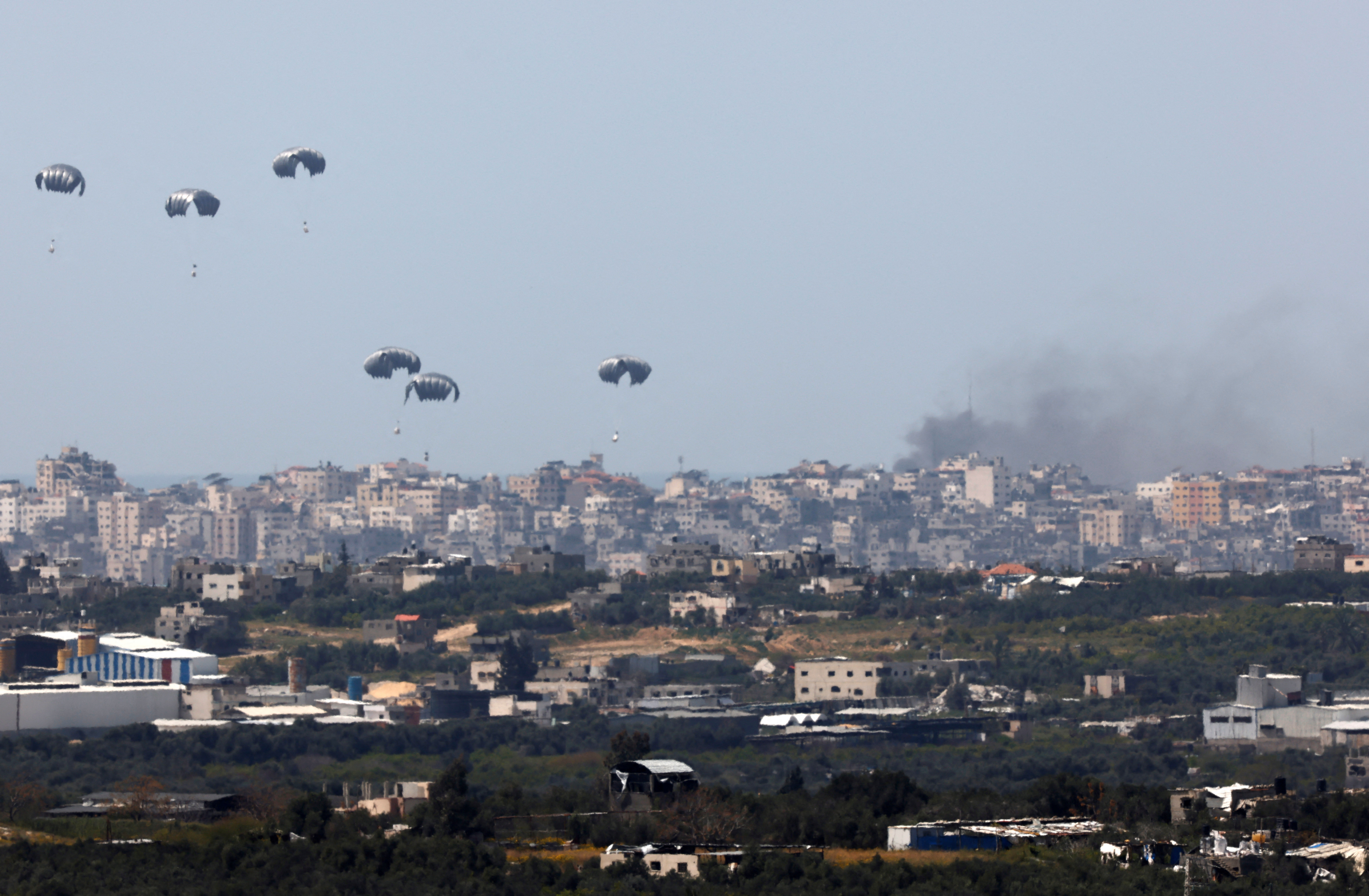 Humanitarian aid falls through the sky towards the Gaza Strip, as seen from Israel's border with Gaza, humanitarna pomoć