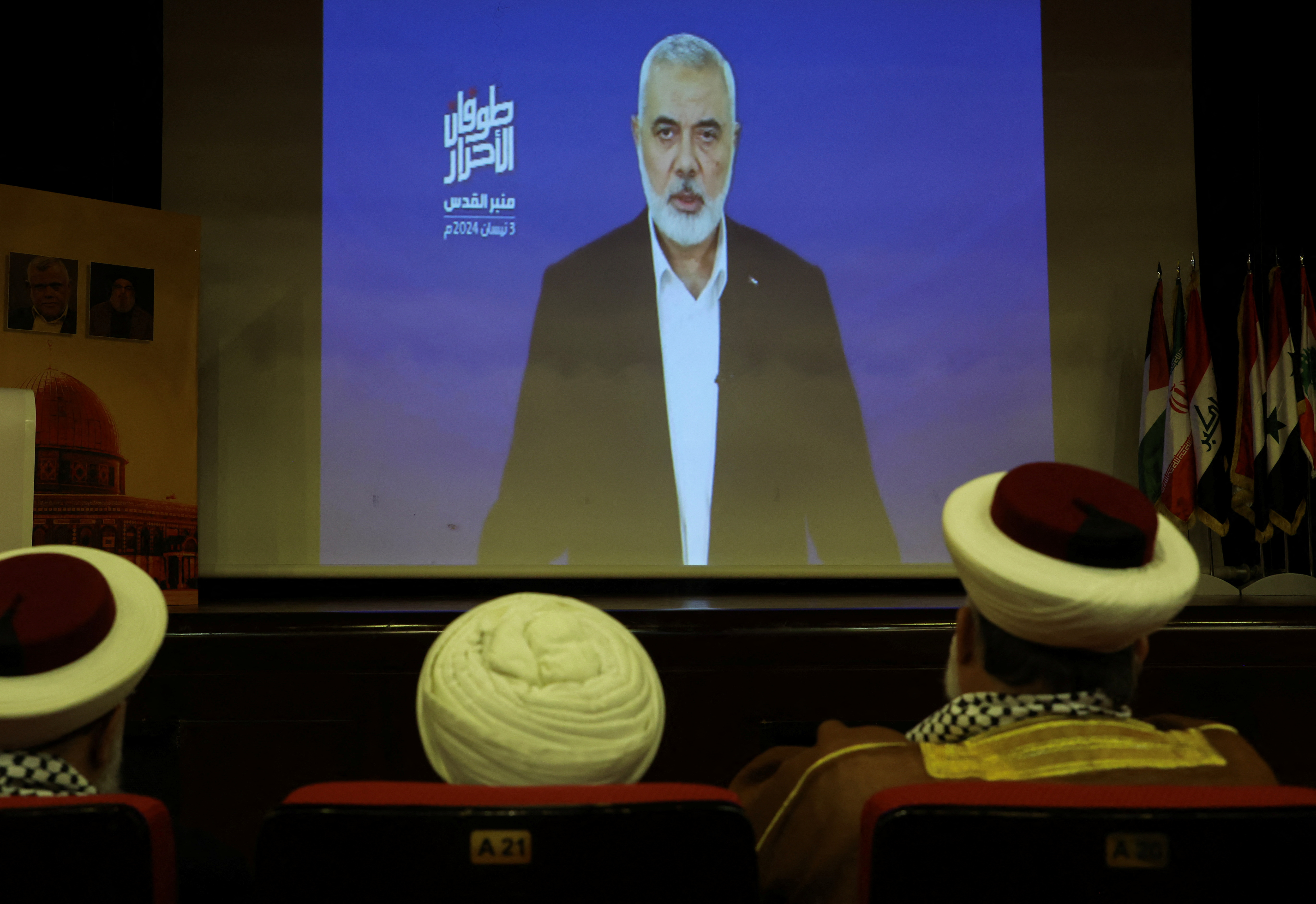 Hamas chief Ismail Haniyeh speaks in a pre-recorded message shown on a screen during an event ahead of al-Quds, in Beirut