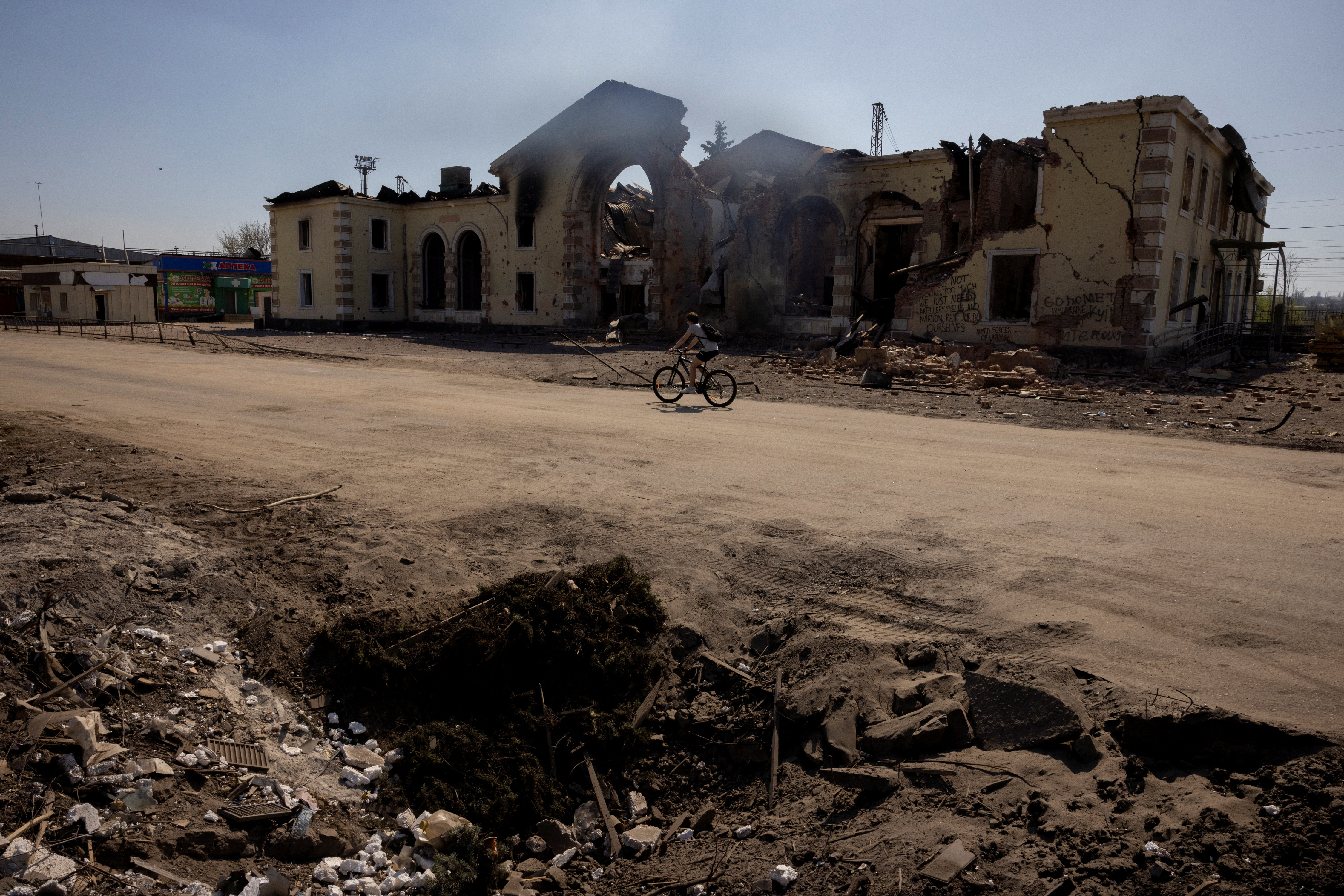 A person cycles past the train station that was damaged by repeated shelling in Kostiantynivka