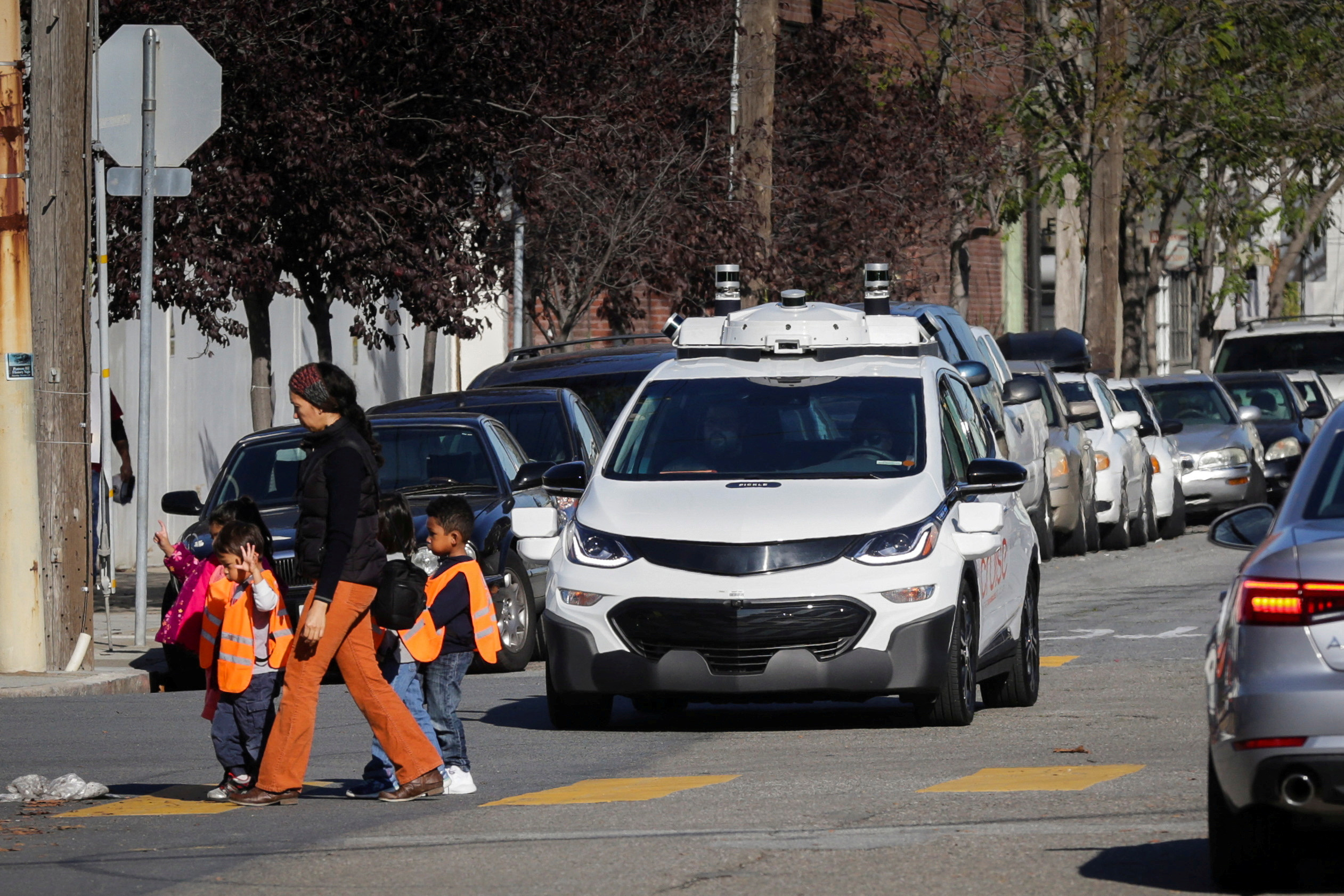 FILE PHOTO: Children pass by a self-driving Chevy Bolt EV car during a media event by Cruise, GM’s autonomous car unit,  in San Francisco