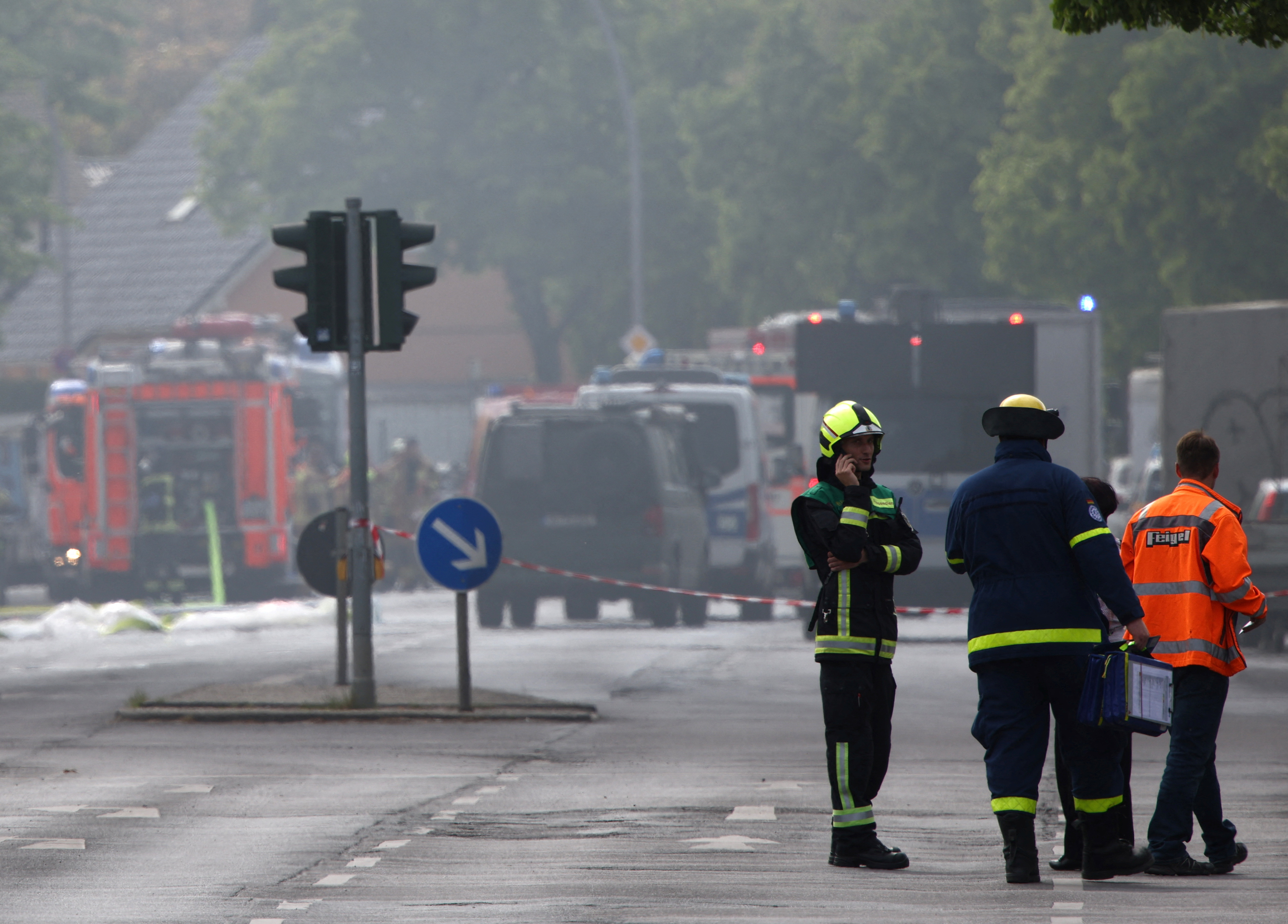 A firefighter talks on the phone as fire engines are lined up after a fire broke out at metal factory in Berlin