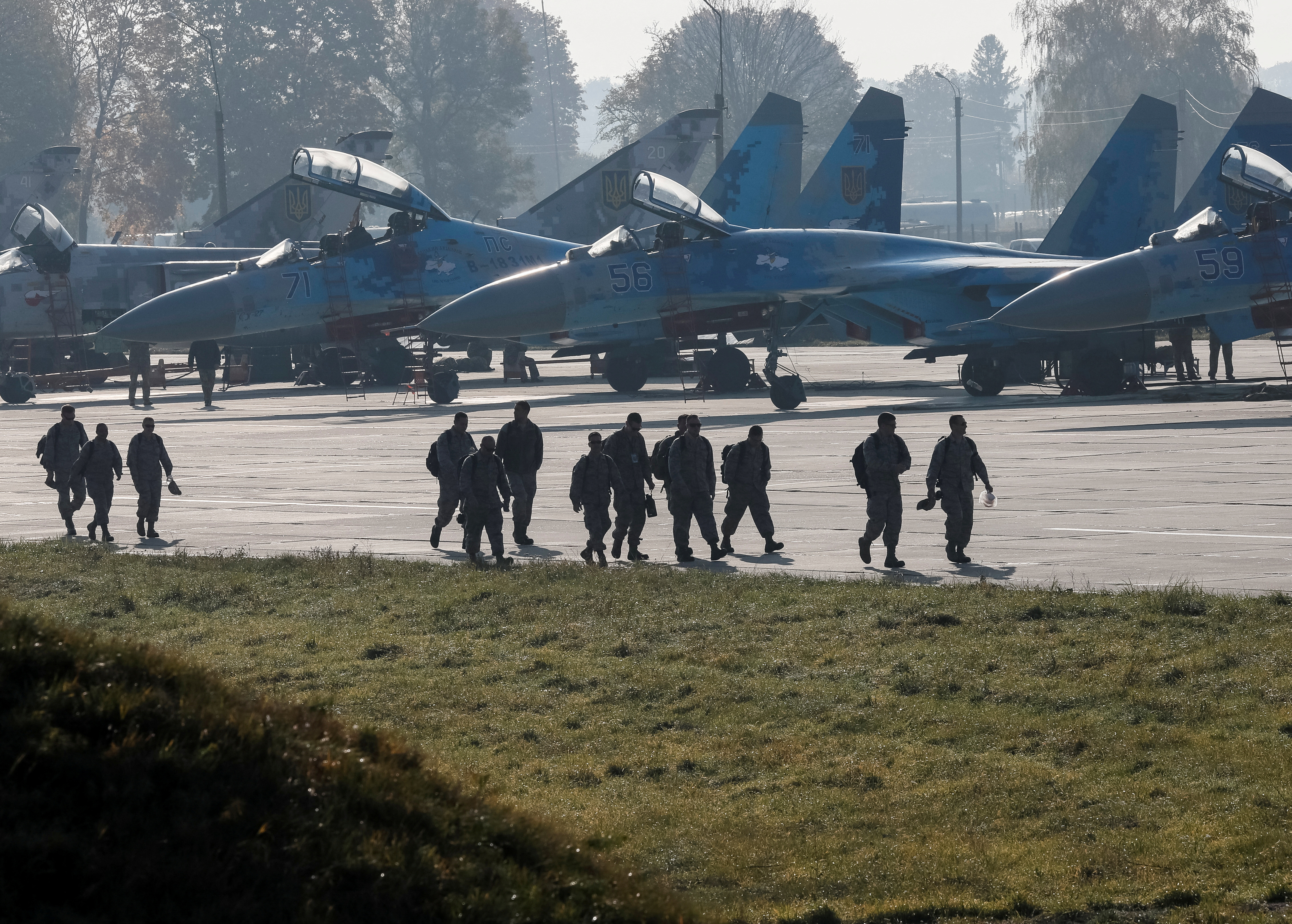 FILE PHOTO: Soldiers of the U.S. army walk past Ukrainian Su-27 fighter jets during a Clear Sky 2018 multinational military drills in Starokostiantyniv