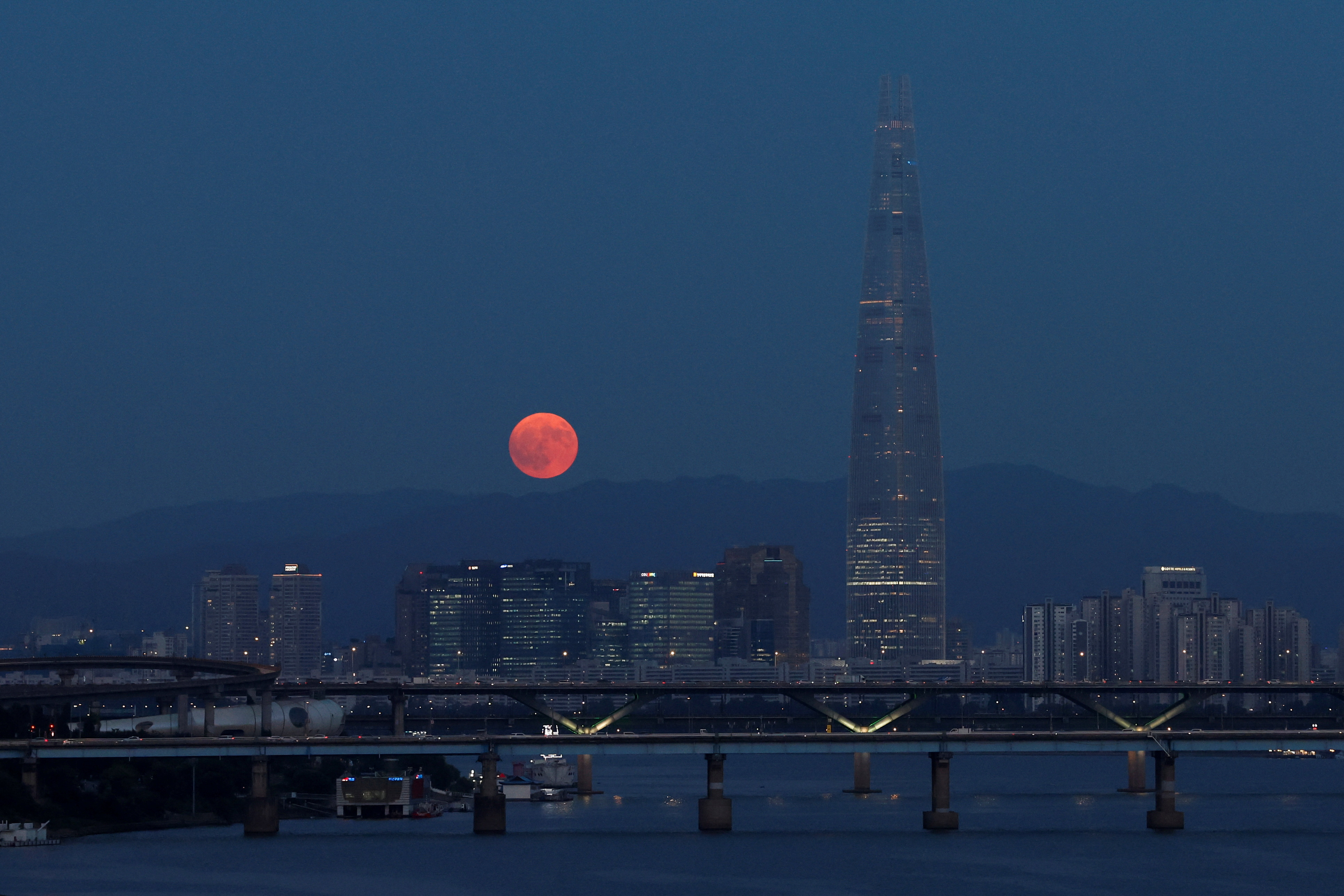 A super moon, known as the Blue Moon, rises next to the 123-story Lotte World Tower in Seoul