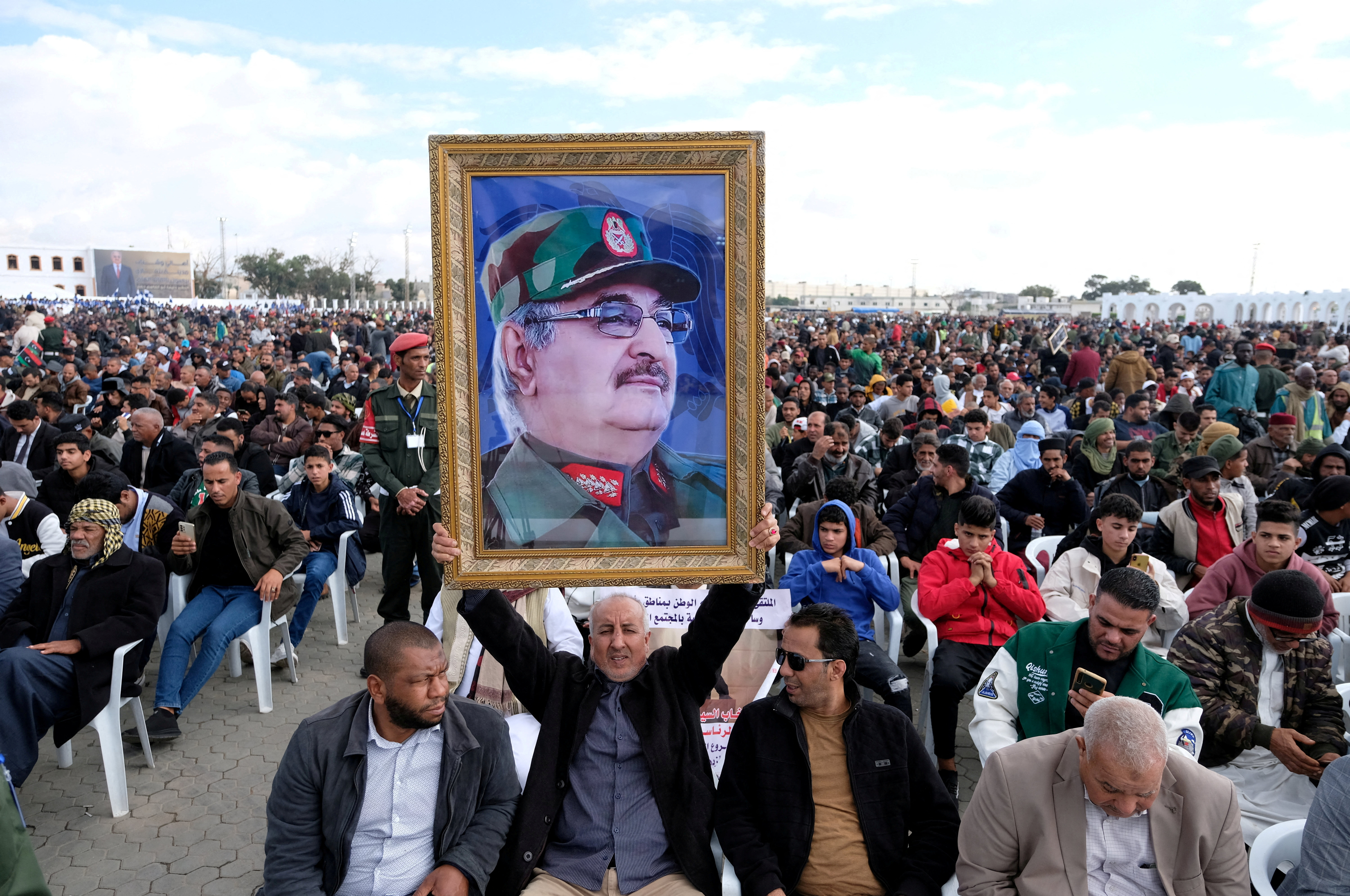 FILE PHOTO: A man holds a picture of commander Khalifa Haftar during Independence Day celebrations in Benghazi