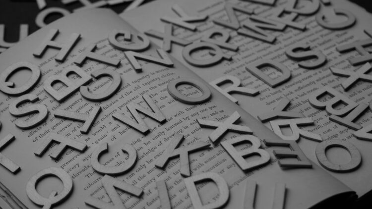 Low,Angle,View,On,Opened,Book,With,English,Printed,Text.