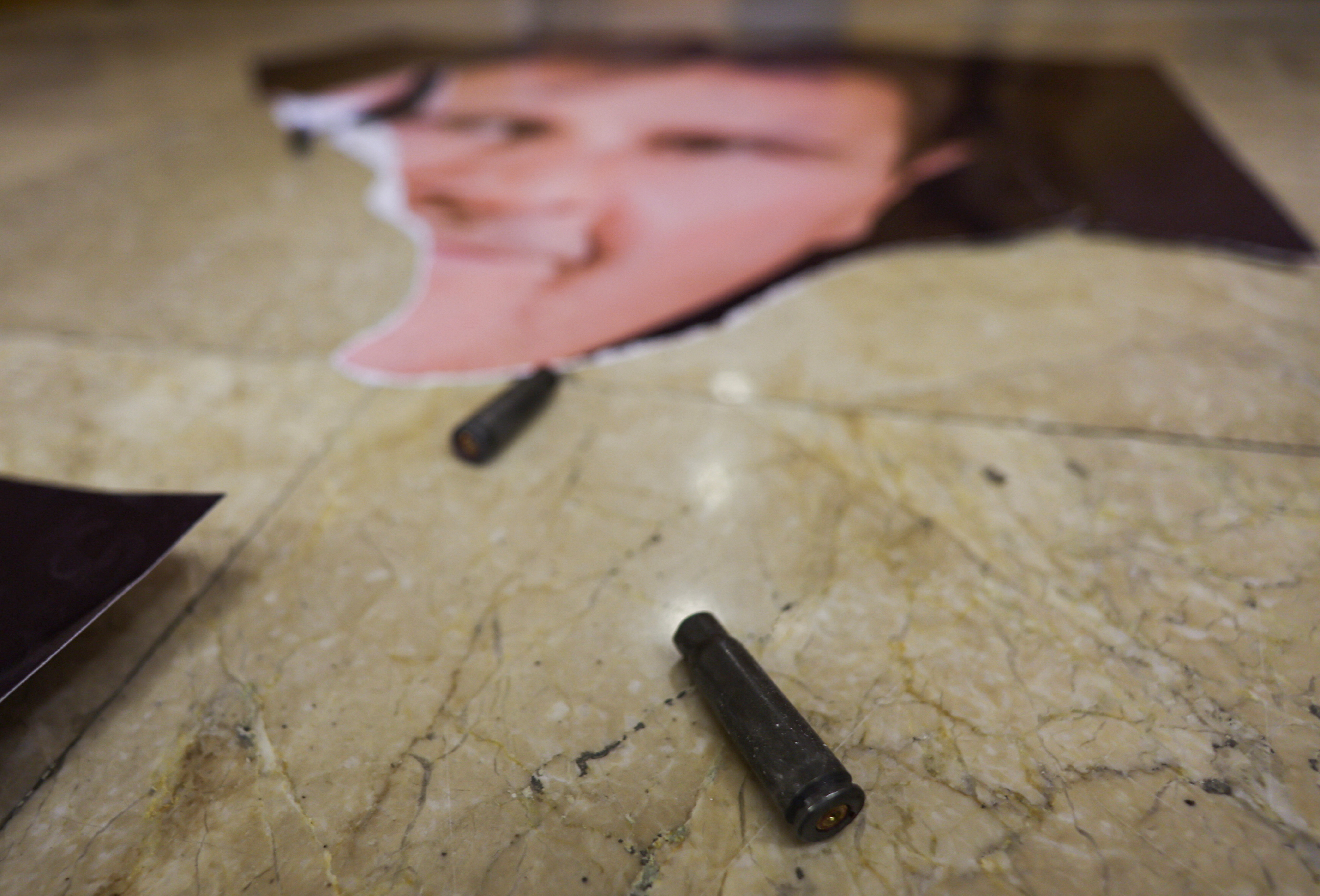 A view of an empty bullet next to a picture of Syria's Bashar al-Assad at one of rooms in Presidential Palace known as Qasr al-Shaab