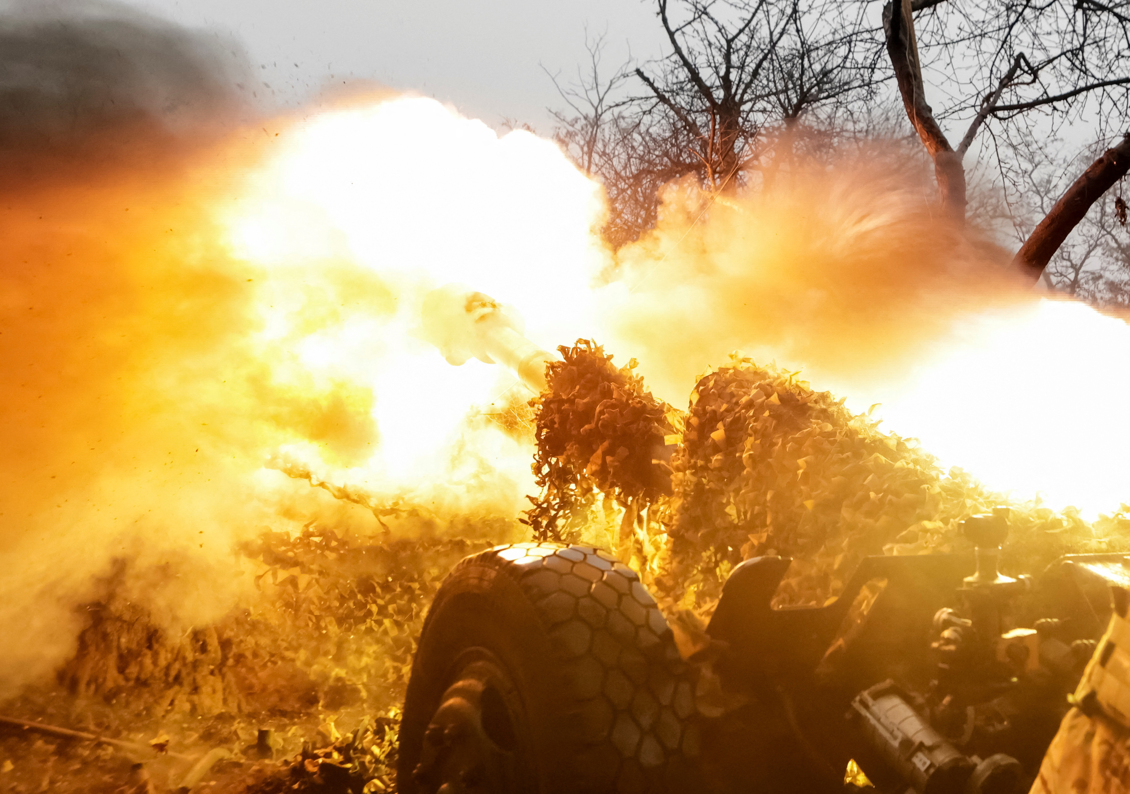 A serviceman of the National Guard of Ukraine fires a howitzer towards Russian troops at a position in a front line in Kharkiv region