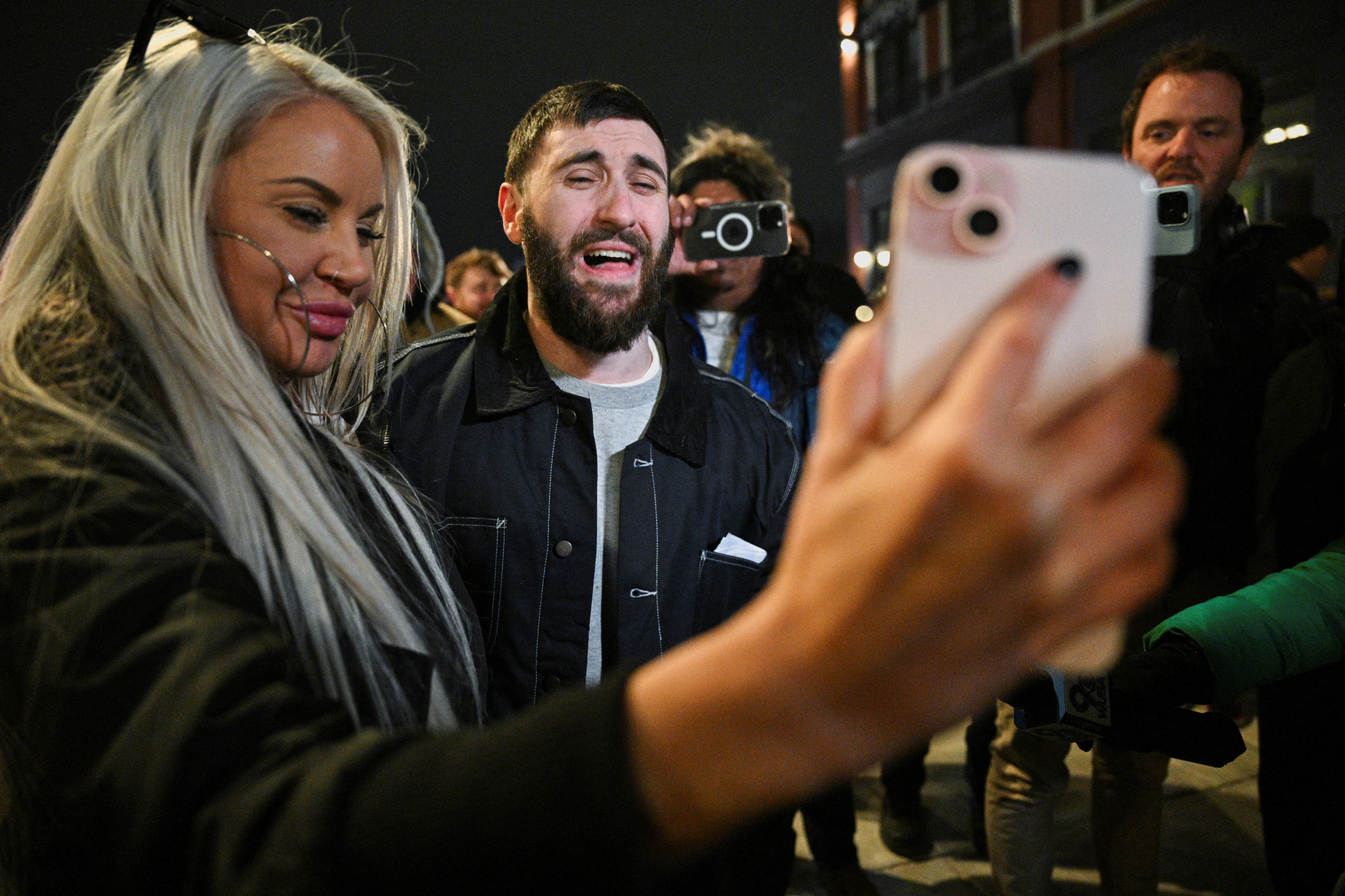 Edward "Jake" Lang, one of the defendants who was released after being pardoned, reacts while his girlfriend, Rachel Myers holds a FaceTime call with Lang’s mother, in Washington