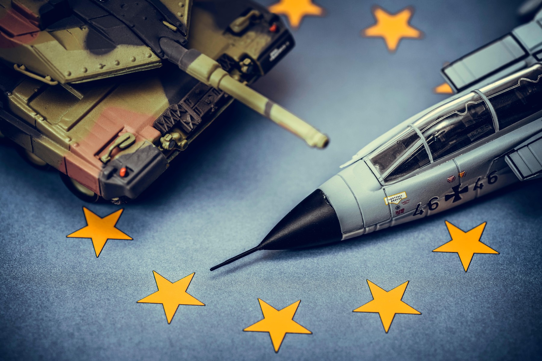 Miniature tank and military jet on EU flag, symbolic photo for a European army, Miniaturpanzer und Militrjet auf EU-Fahne, Symbolfoto fr eine europ