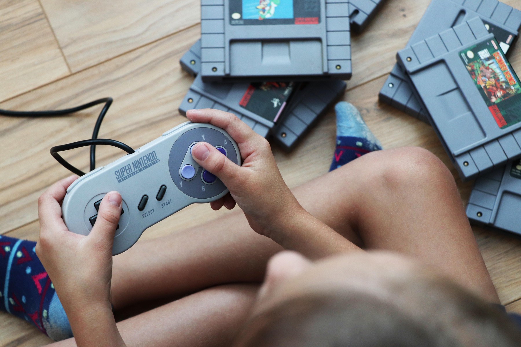 A little child playing original Super Nintendo