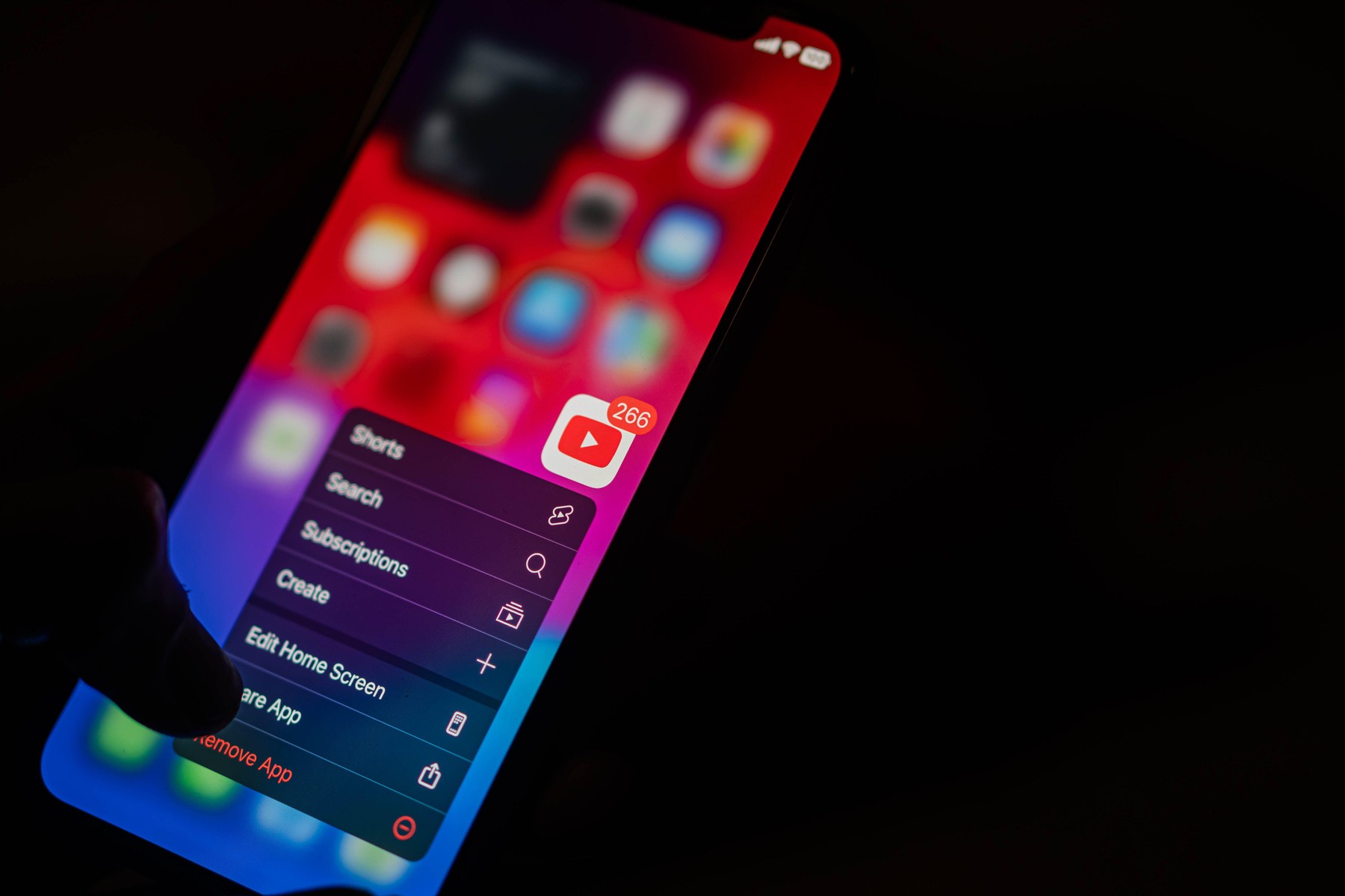 A close-up of a smart phone screen displaying the YouTube app with a notification badge showing 266 notifications. The screen is in dark mode, and the