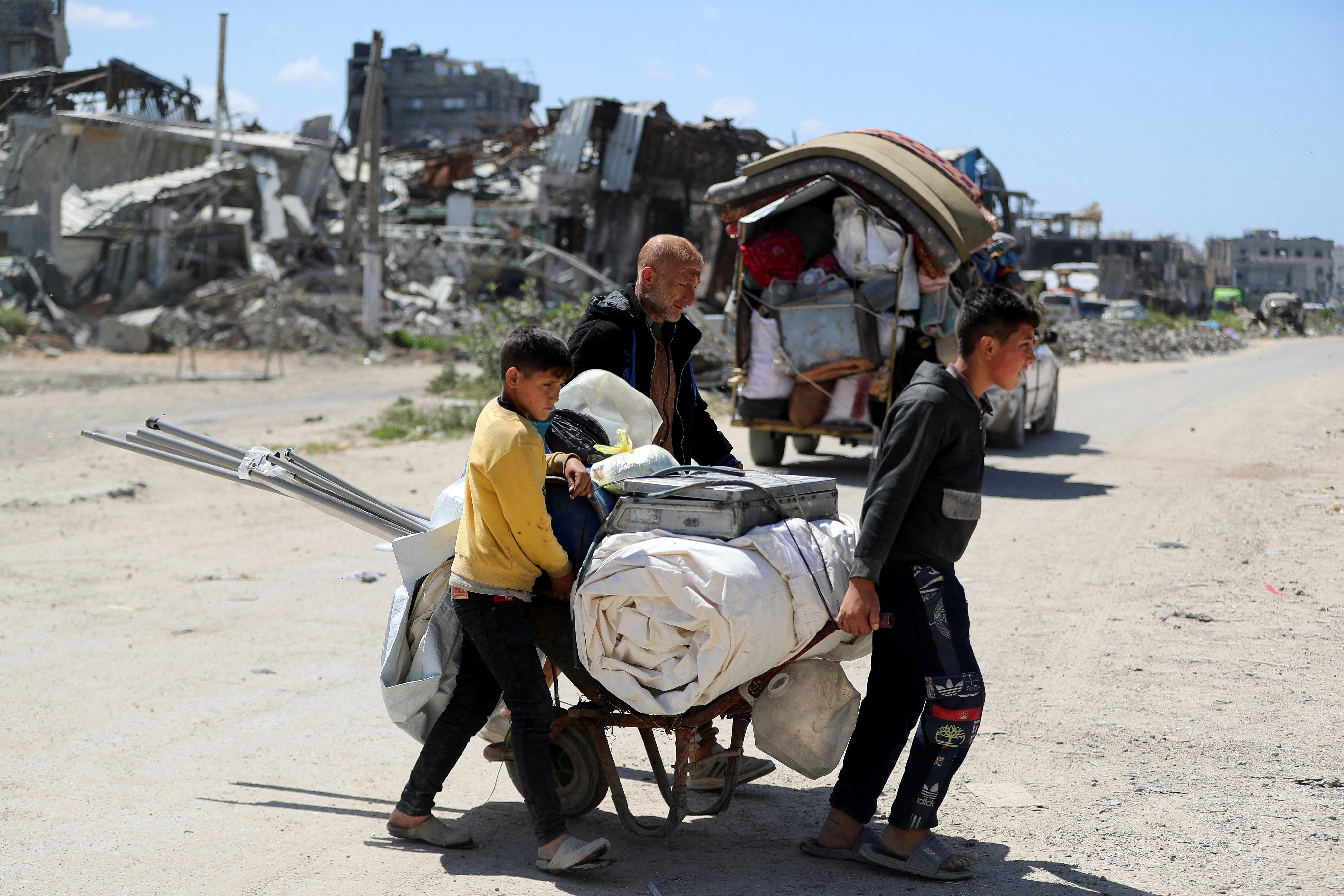 Palestinians make their way to flee their homes, after the Israeli army issued evacuation orders for a number of neighborhoods, following heavy Israeli strikes, in the northern Gaza Strip