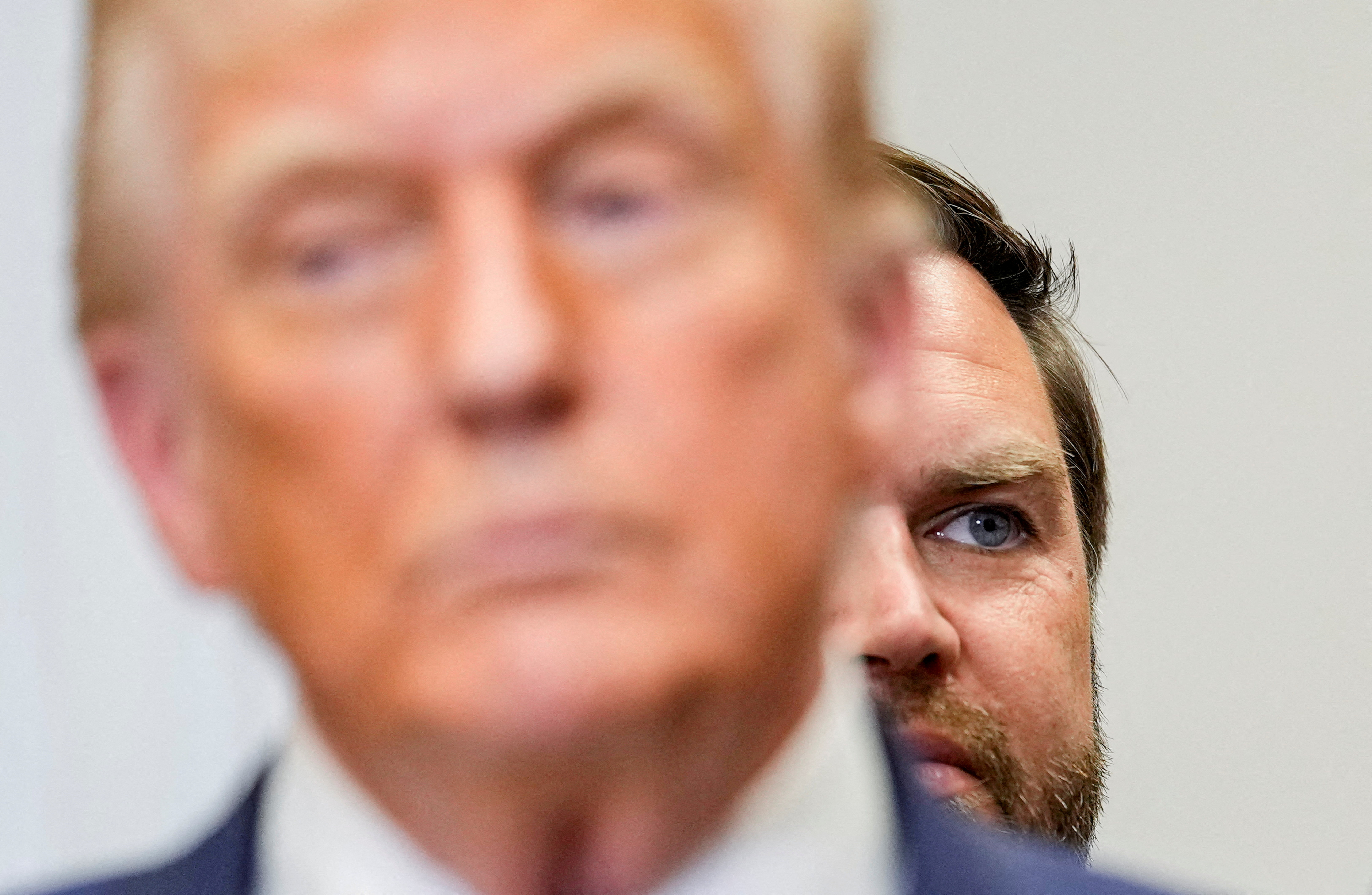 FILE PHOTO: U.S. Vice President JD Vance looks on from behind President Donald Trump during an event at the Roosevelt Room of the White House in Washington, D.C., U.S., July 31, 2025. REUTERS/Kent Nishimura/File Photo
