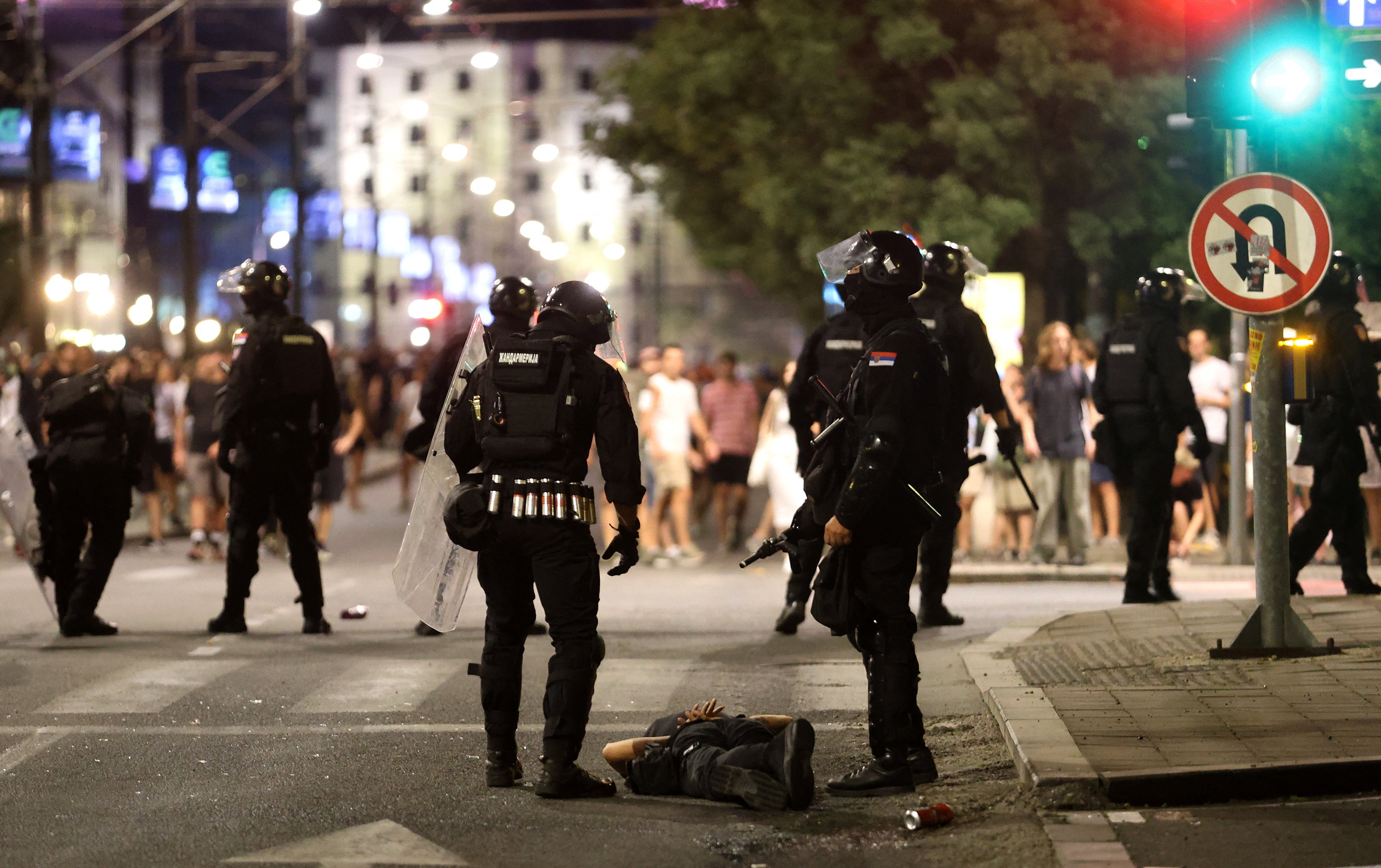 Serbian police stand next to a detaine a protester during standoff between supporters of the ruling Serbian Progressive Party (SNS) and anti-government protesters, in Belgrade, Serbia, August 13, 2025. REUTERS/Djordje Kojadinovic