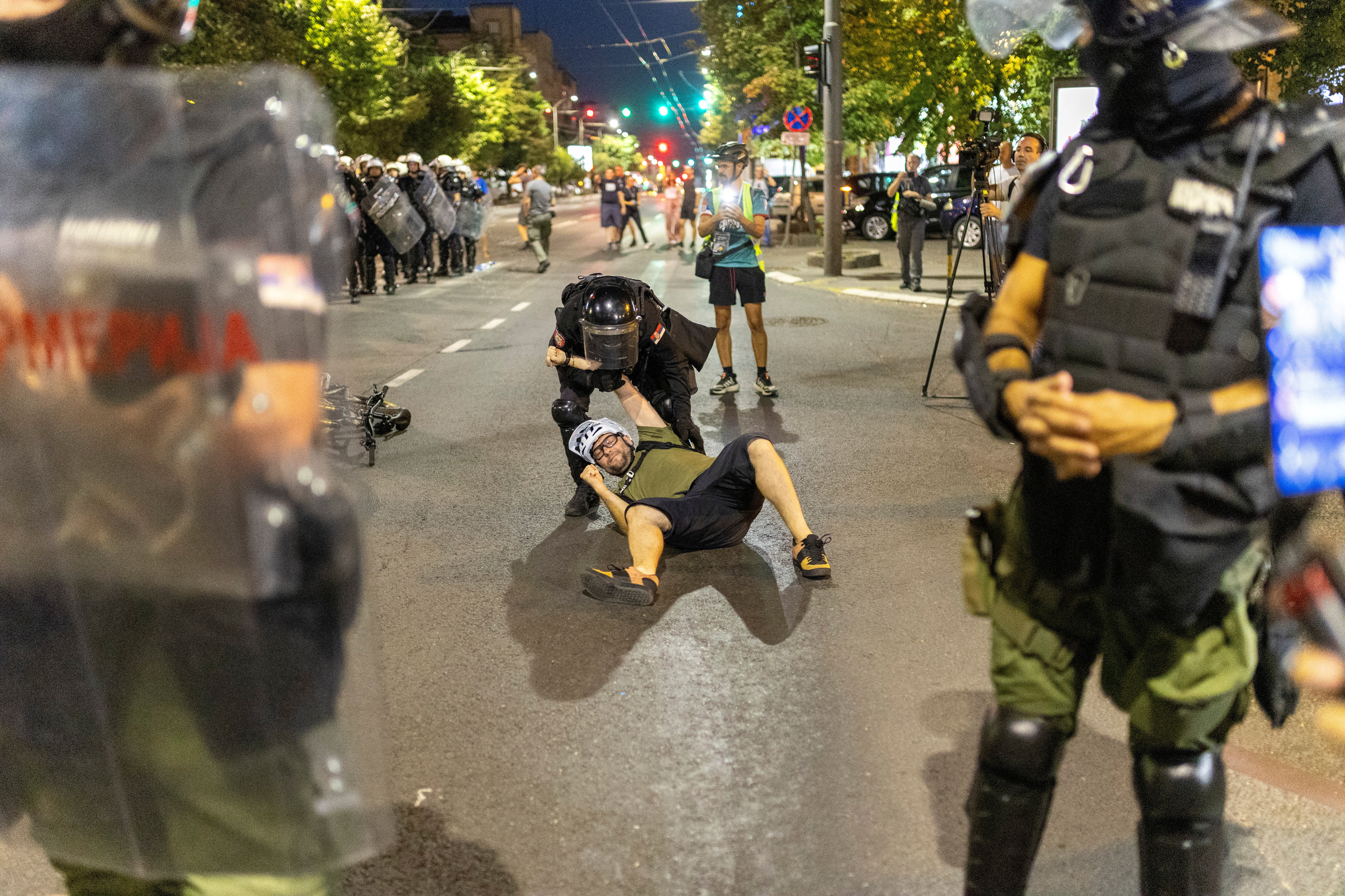 A Serbian police officer detains a person, during a standoff between supporters of the ruling party and anti-government protesters in Belgrade, Serbia, August 14, 2025. REUTERS/Djordje Kojadinovic