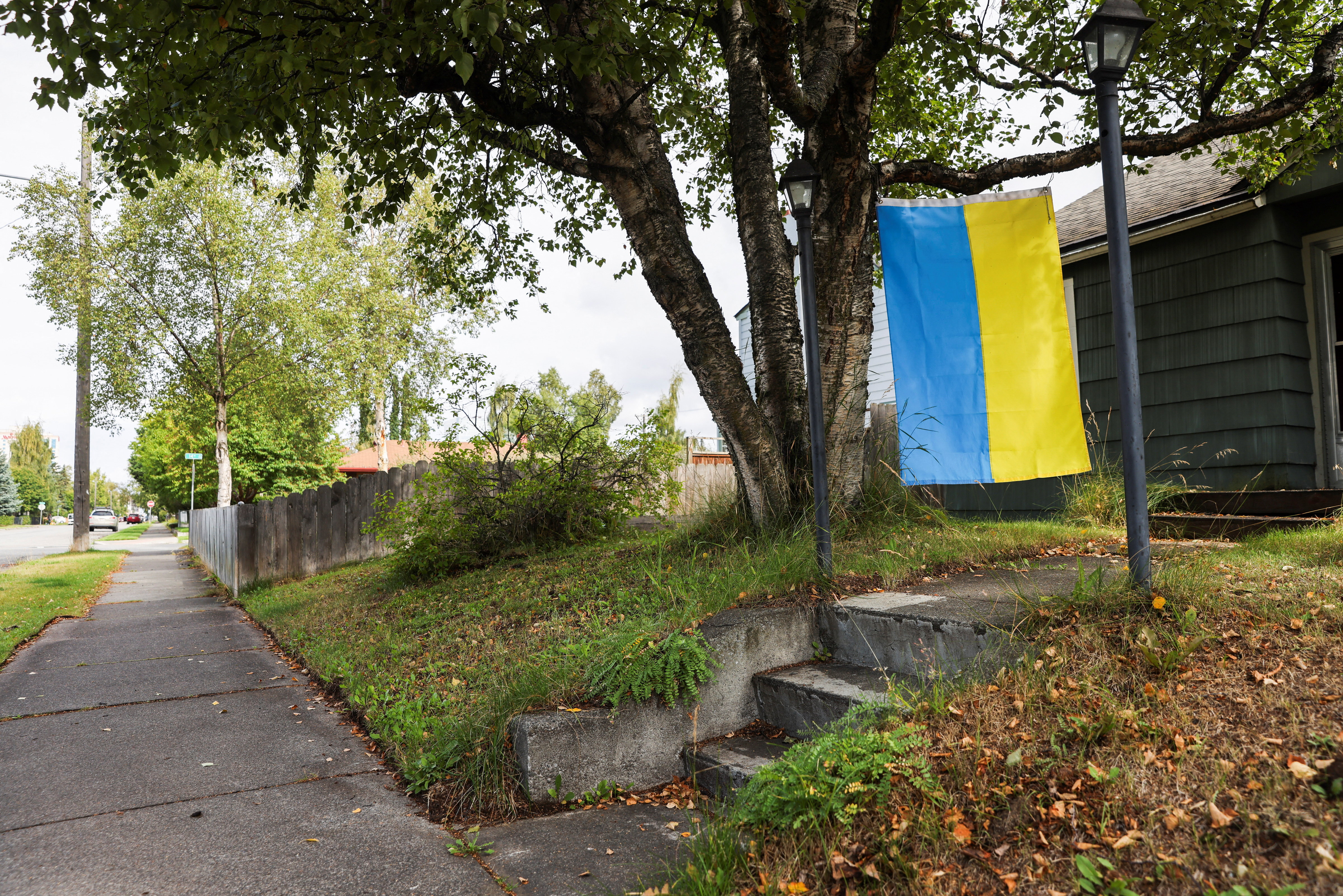 A Ukrainian flag hangs infront of a house, ahead of the meeting between U.S. President Donald Trump and Russian President Vladimir Putin, in Anchorage, Alaska, U.S., August 14, 2025.  REUTERS/Nathaniel Wilder