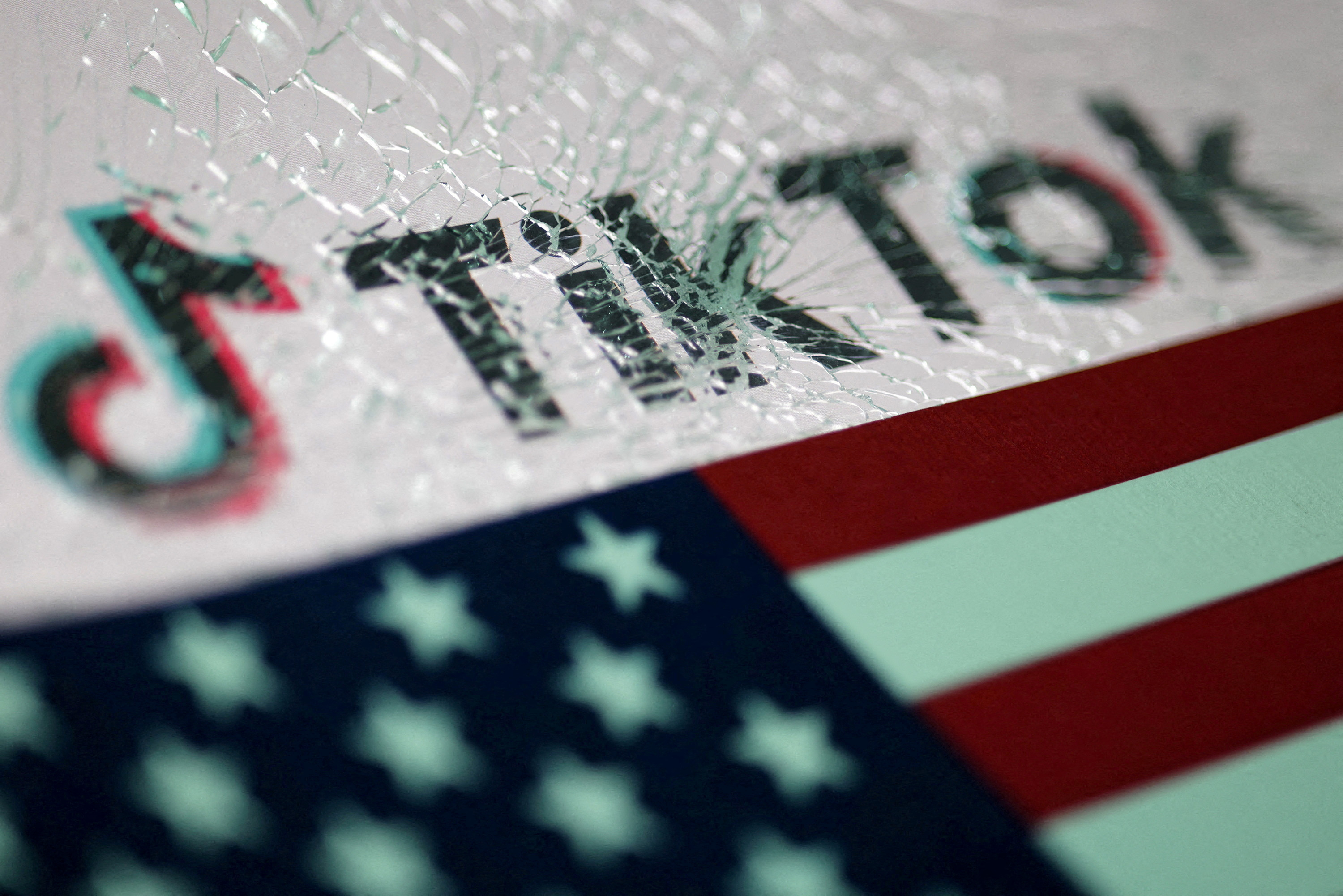 FILE PHOTO: The U.S. flag and the TikTok logo seen through broken glass are seen in this illustration taken January 16, 2025. REUTERS/Dado Ruvic/Illustration/File Photo/File Photo