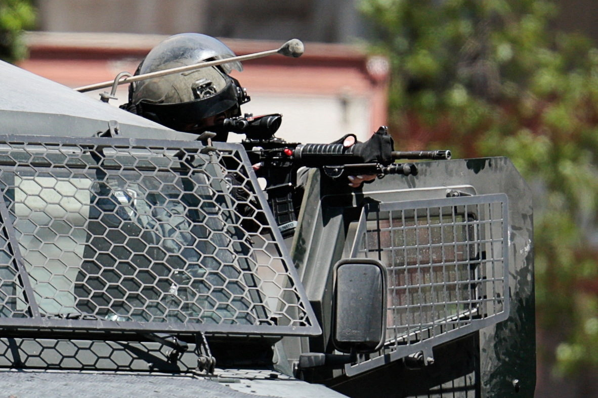 A member of the Israeli forces holds a gun, during an Israeli raid in Ramallah, in the Israeli-occupied West Bank, August 26, 2025.