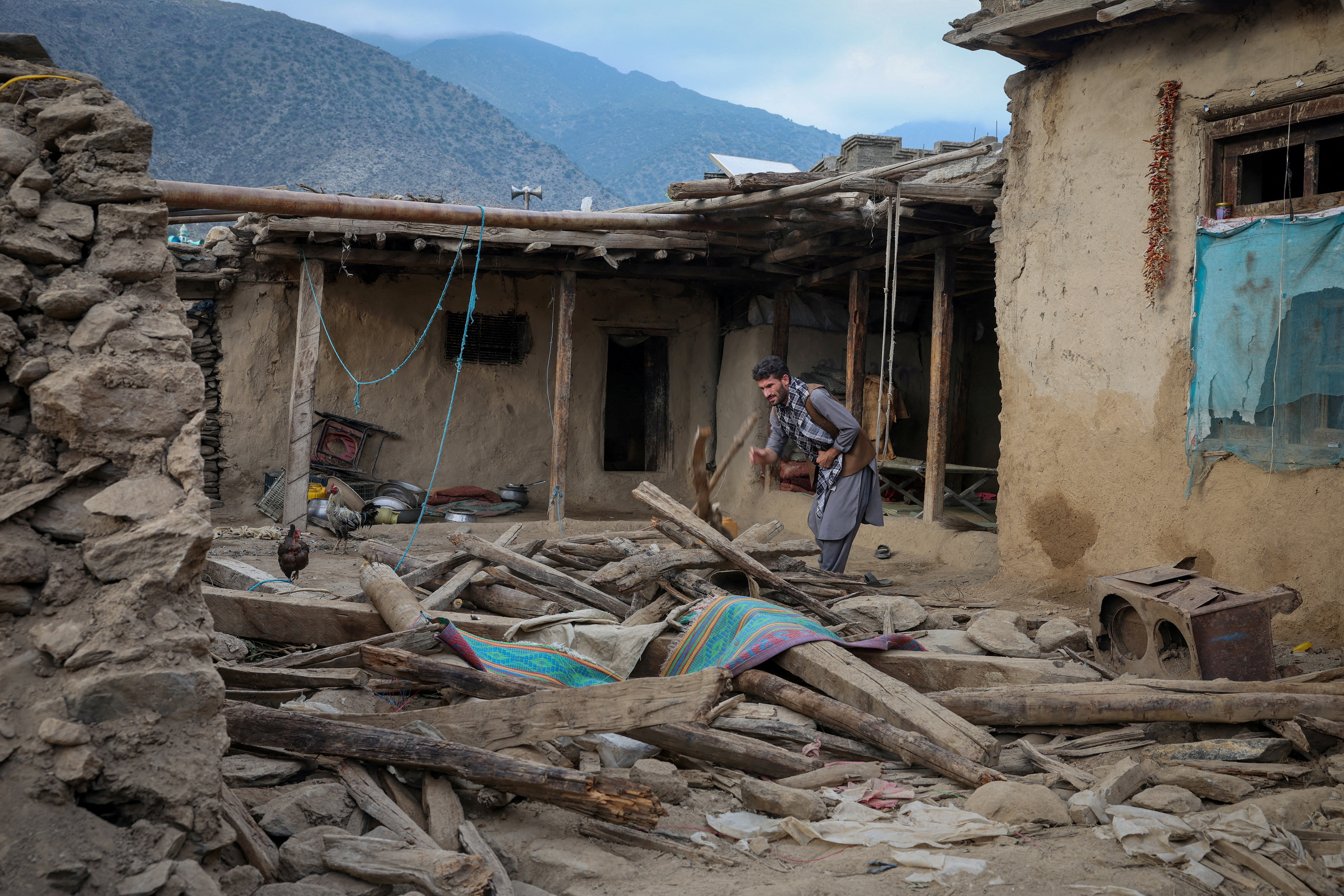 FILE PHOTO: An Afghan man looks for his belongings amidst the rubble