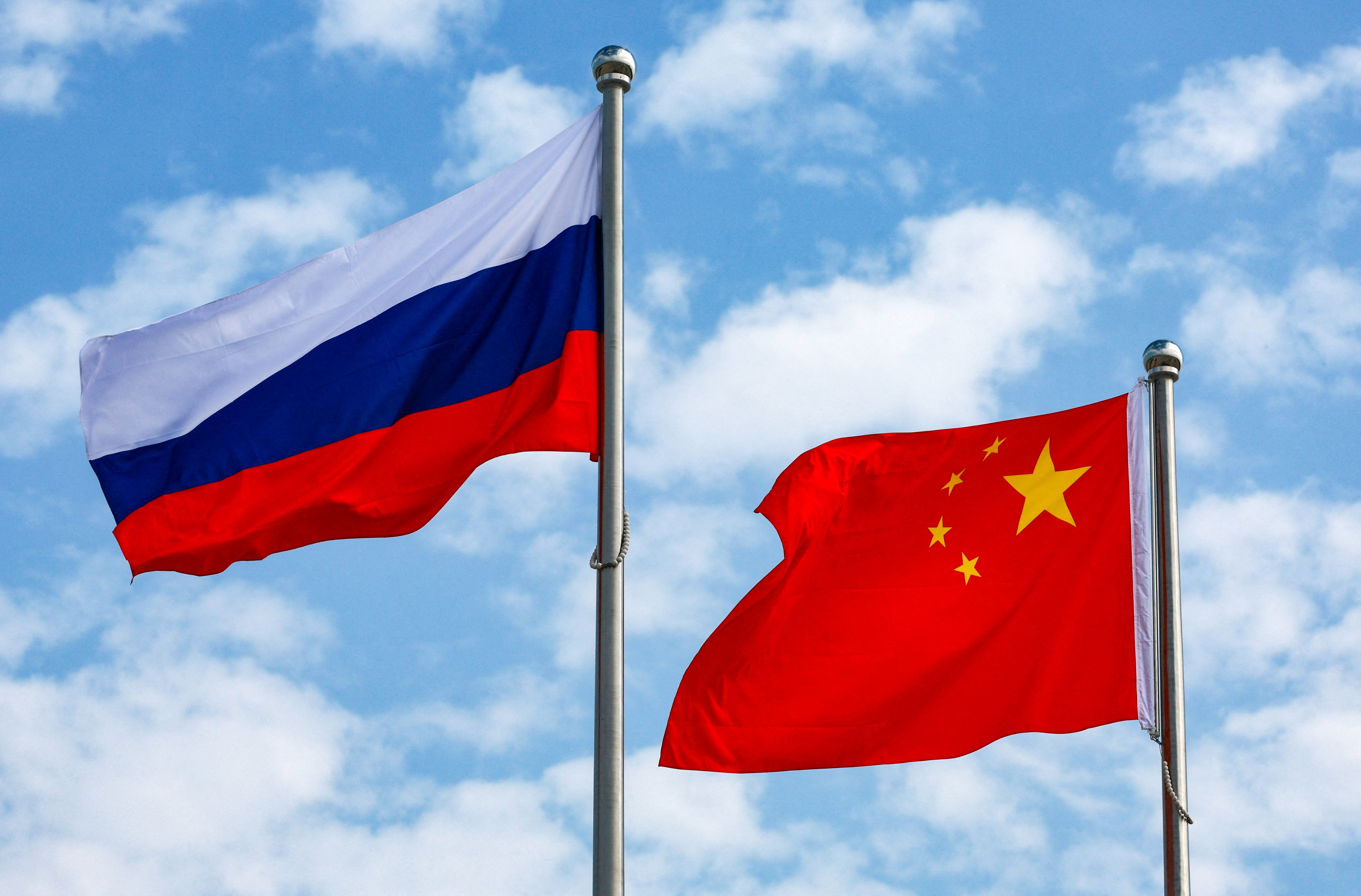 Chinese and Russian flags fly at an airport before a ceremony to welcome Russian President Vladimir Putin, who arrives to attend the Shanghai Cooperation Organisation (SCO) summit in Tianjin, China