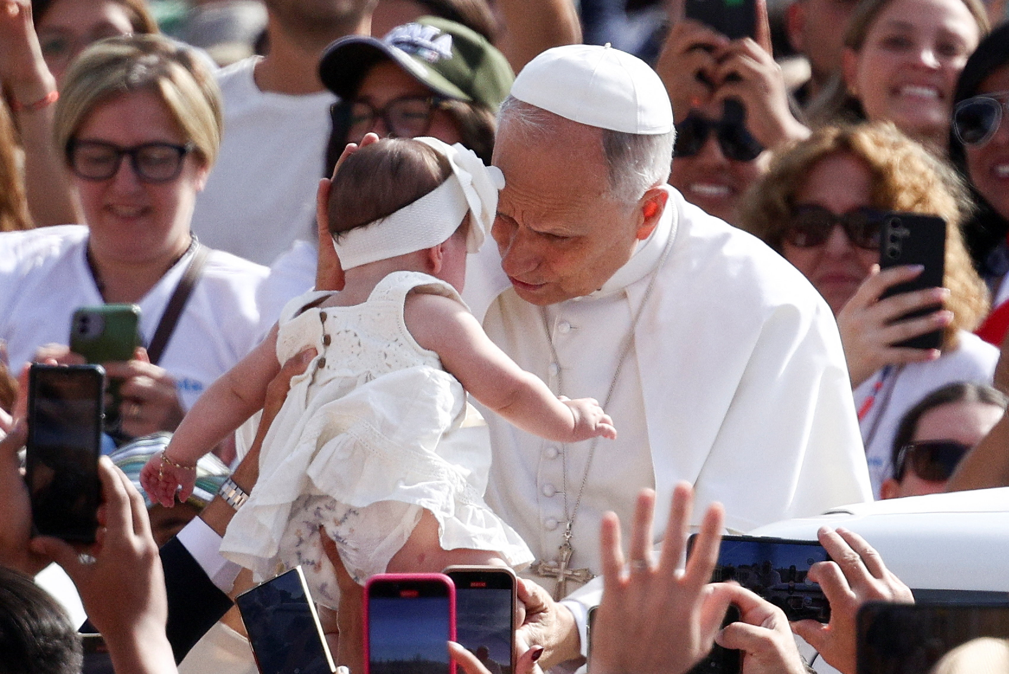 Pope Leo XIV interacts with a child on the day he holds a general audience in St. Peter's Square at the Vatican, September 3 , 2025. REUTERS/Guglielmo Mangiapane