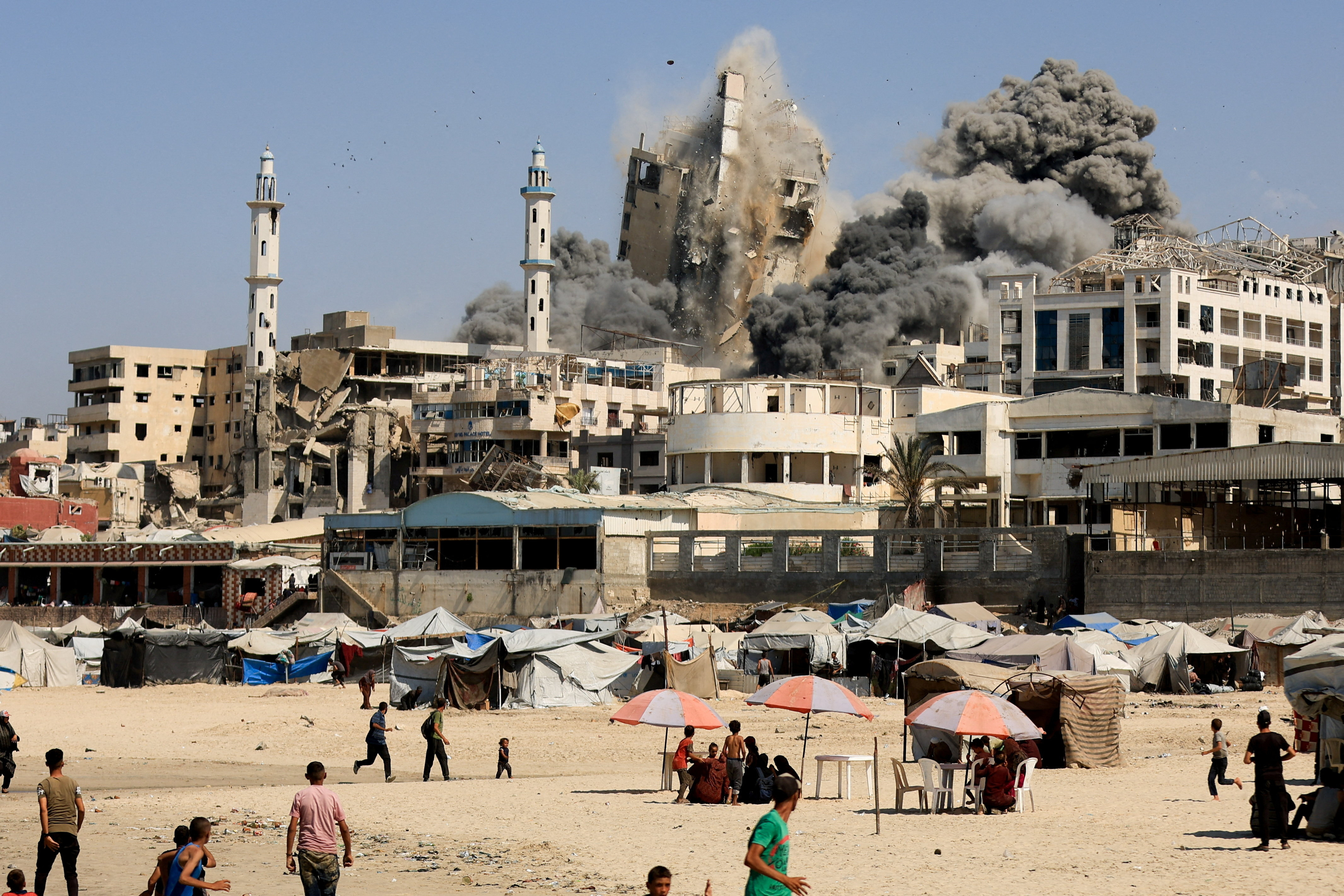 Smoke rises from the evacuated Al-Ghefari tower, as it collapses after it was hit by Israeli air strikes, in Gaza City