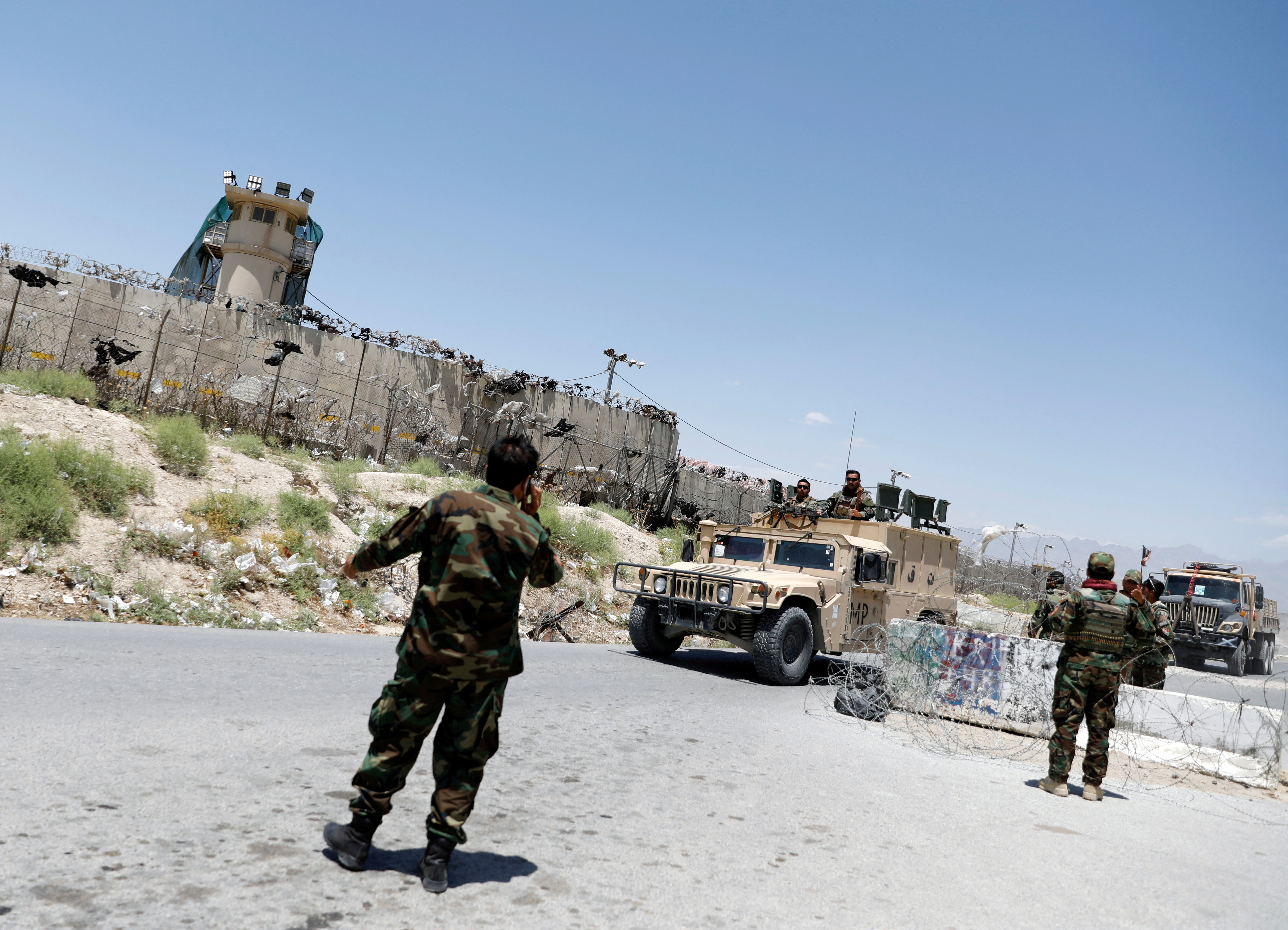 FILE PHOTO: Afghan soldiers stand guard at a checkpoint outside the U.S Bagram air base, on the day the last of American troops vacated it, Parwan province, Afghanistan July 2, 2021.REUTERS/Mohammad Ismail/File Photo