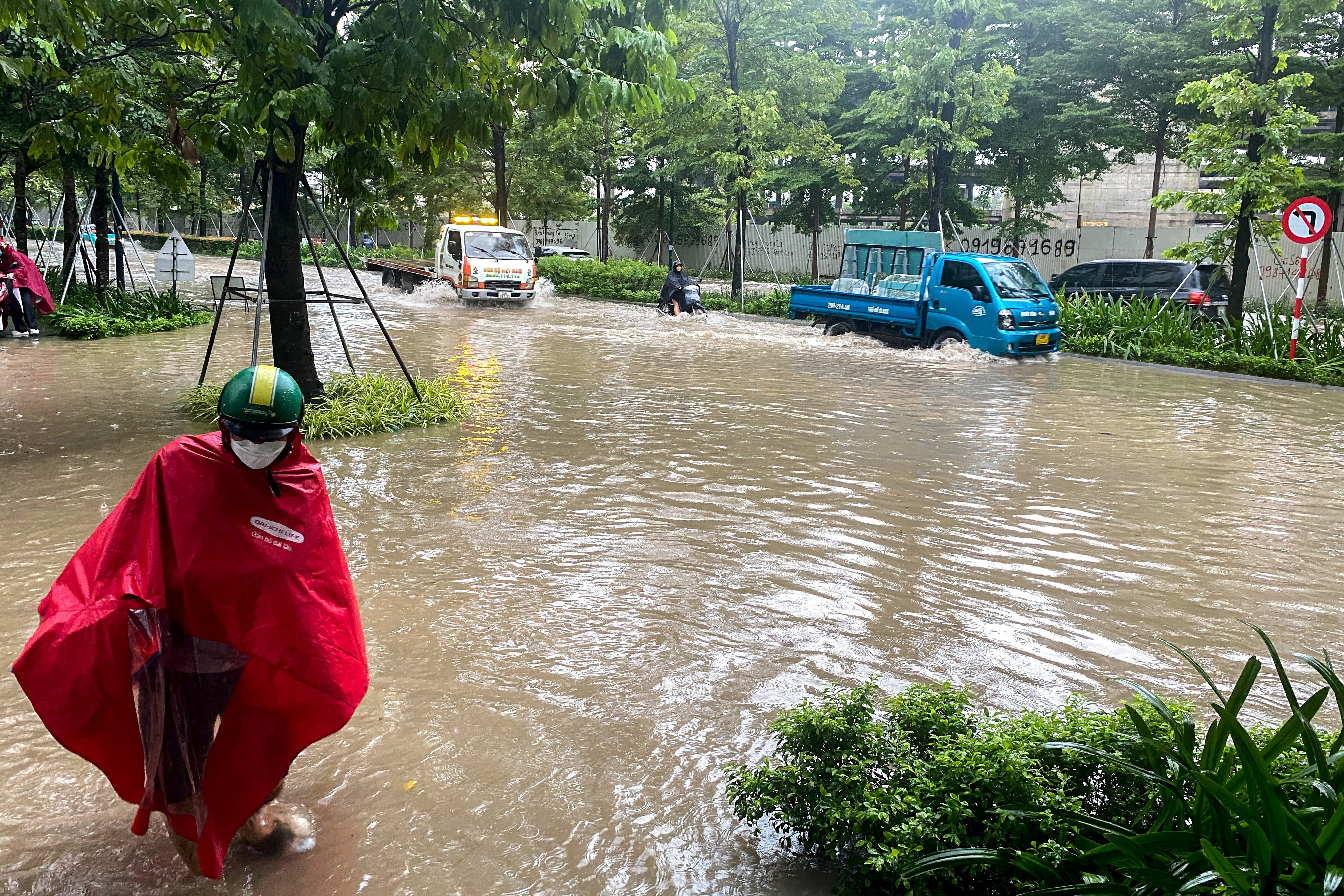 People commute on a flooded street after Typhoon Bualoi made landfall in Hanoi, Vietnam, September 30, 2025. REUTERS/Frencesco Guarascio