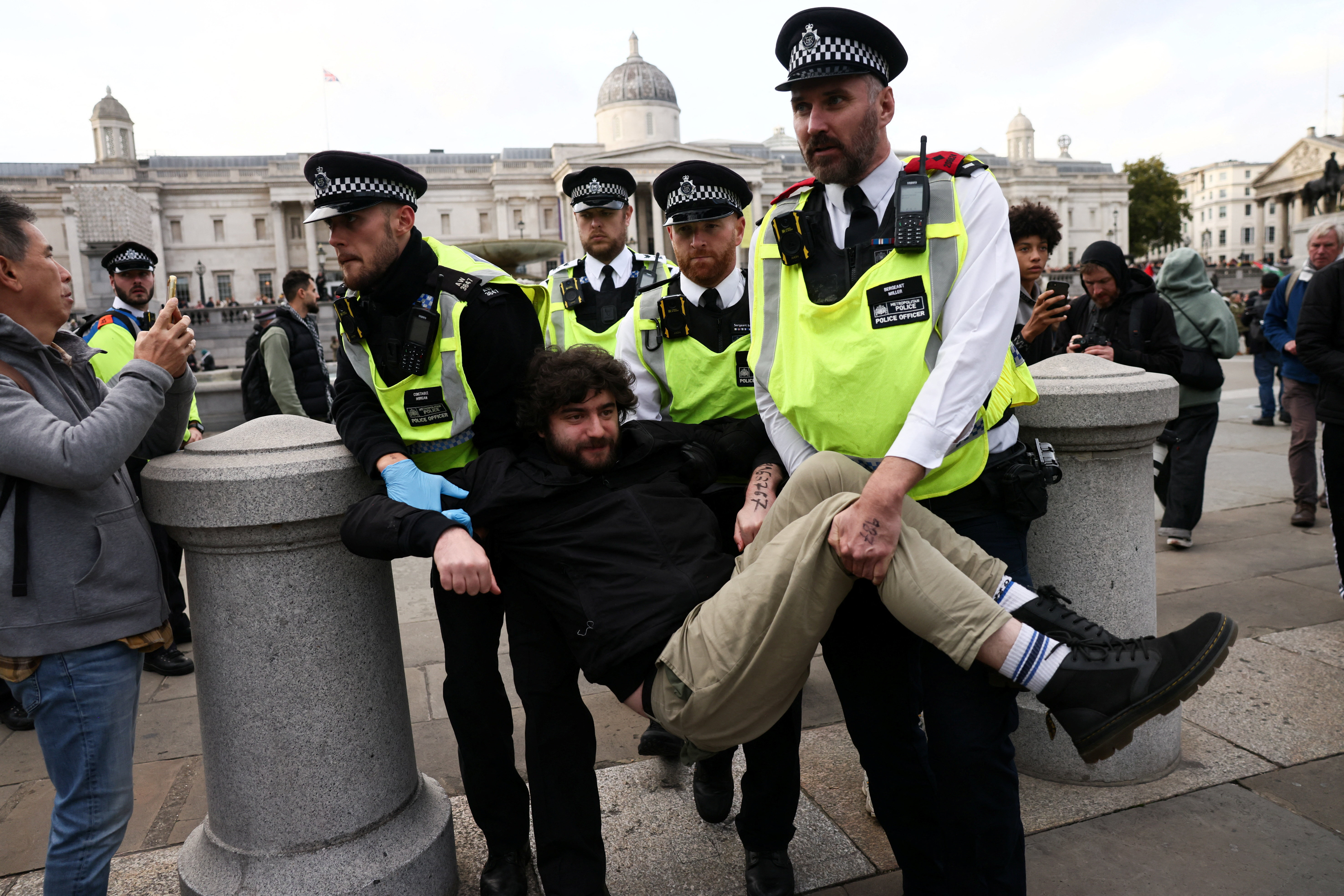 Police officers detain a protester during a mass demonstration organised by Defend our Juries, against the British government's ban on Palestine Action, in London, Britain, October 4, 2025. REUTERS/Jack Taylor